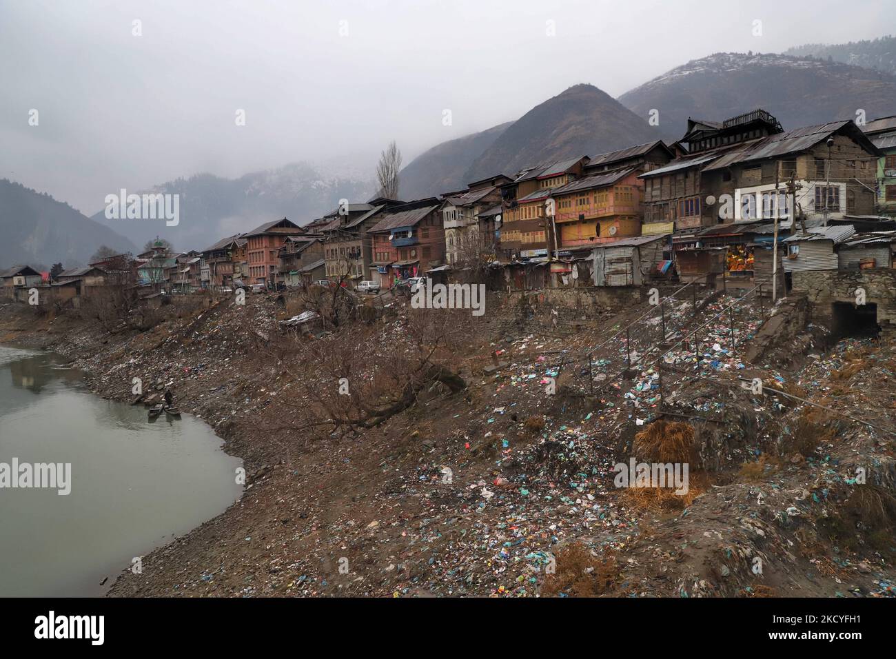 Müll wird am Ufer des Flusses gesehen, wie Wohnhäuser am 27. Dezember 2021 in Baramulla, Jammu und Kashmir, Indien, gesehen werden. (Foto von Nasir Kachroo/NurPhoto) Stockfoto