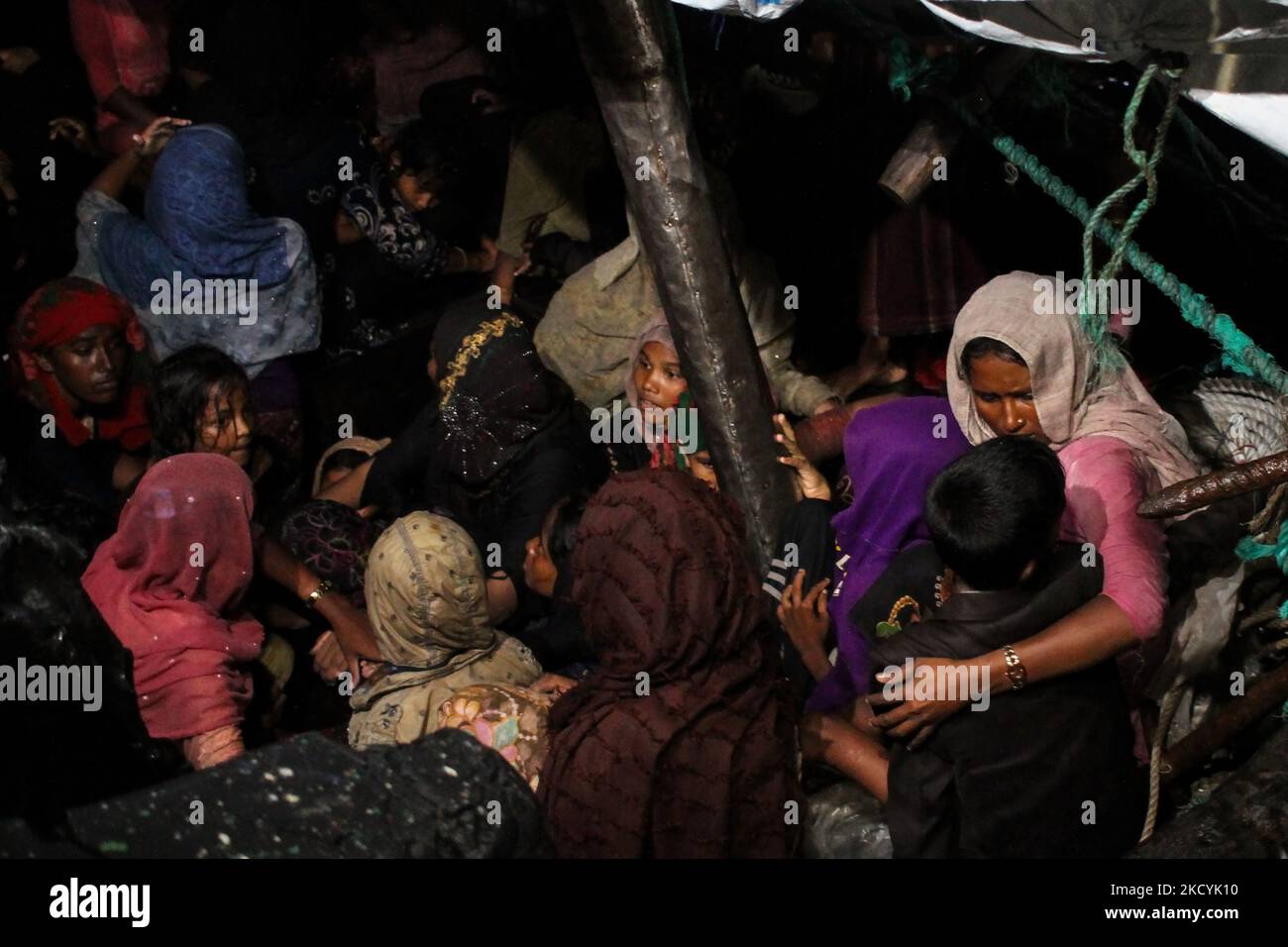 Rohingya-Flüchtlinge werden auf dem Deck eines Holzboots sitzen sehen, während sie von der indonesischen Marine evakuiert werden, nachdem sie am 31. Dezember 2021 in den Biruen-Gewässern im Hafen Krueng Geukueh, im Norden des Regency Aceh, Indonesien. (Foto von Fachrul Reza/NurPhoto) Stockfoto