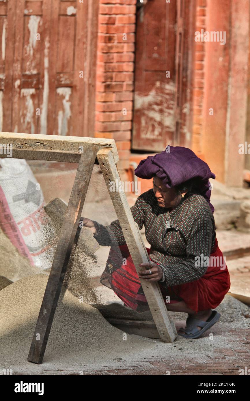 Frau, die feinen Sand für den Bau in der antiken Stadt Bhaktapur in Nepal durchsiebe. (Foto von Creative Touch Imaging Ltd./NurPhoto) Stockfoto