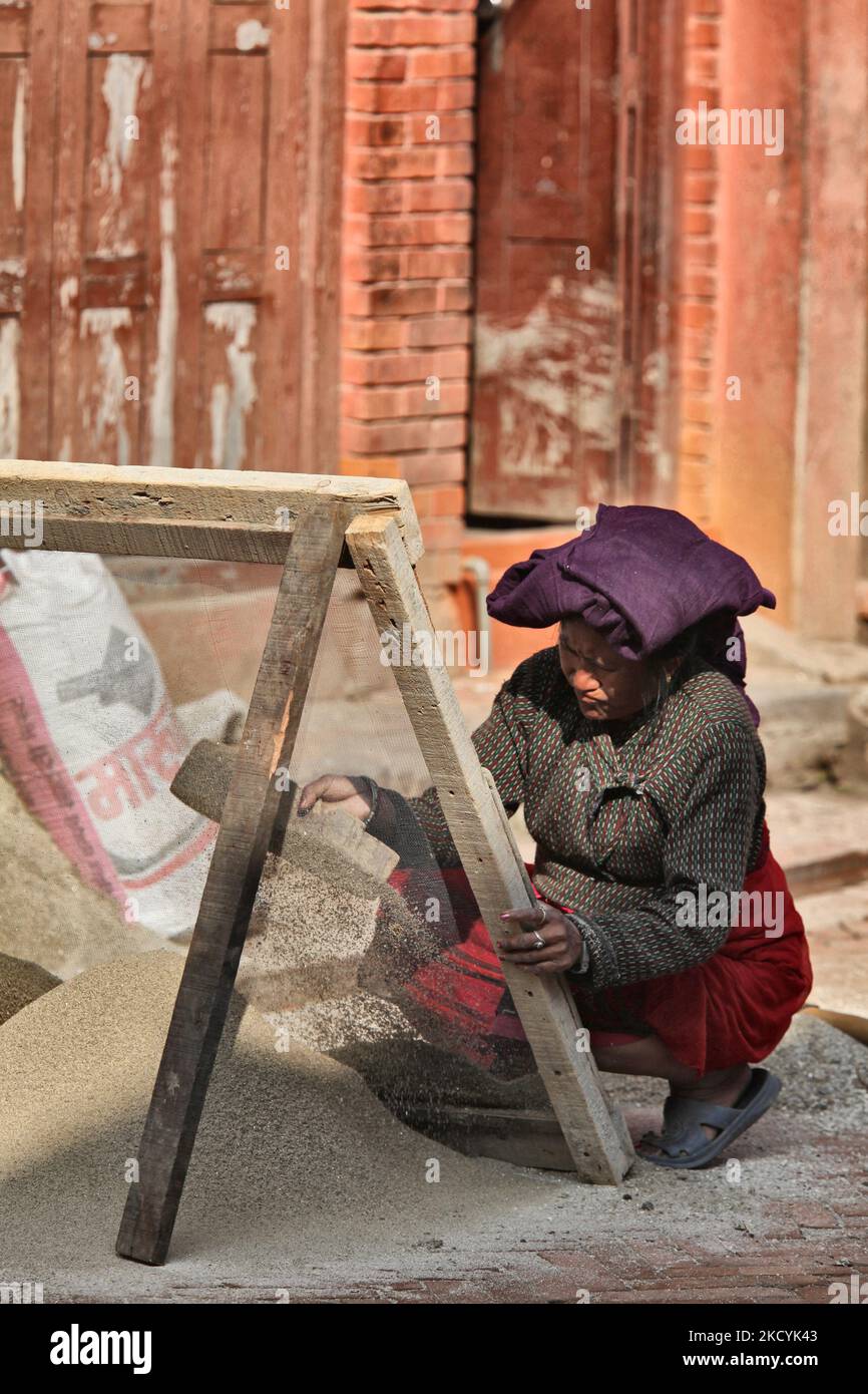 Frau, die feinen Sand für den Bau in der antiken Stadt Bhaktapur in Nepal durchsiebe. (Foto von Creative Touch Imaging Ltd./NurPhoto) Stockfoto