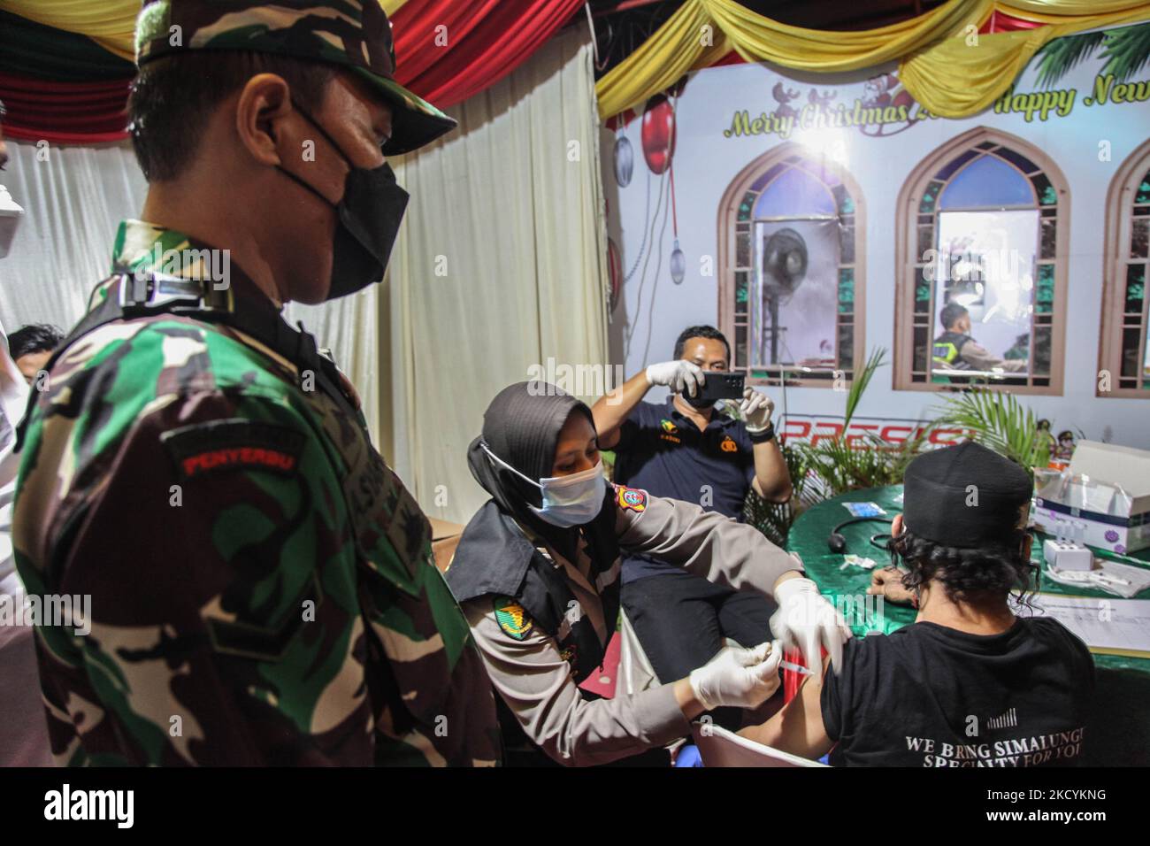 Gesundheitshelfer nehmen Tupfer aus Personenbussen und blockieren Straßen, die zum Stadtplatz führen, um die Silvesterfeiern am 31. Dezember 2021 in Medan, Indonesien, einzuschränken. Mehrere Länder und Städte bereiten auch Feuerwerkspartys vor, trotz des Ausbruchs der Omicron-Variante, um das neue Jahr 2022 begrüßen zu können. Als ein Land, das nach der Entdeckung des ersten lokal übertragenen Falls der Omicron COVID-19-Variante Menschenmengen erwartet, indem es wegen der Entdeckung des Omicron-Falls, der derzeit 68 Fälle umfasst, Beschränkungen für Silvester verhängt hat, wo die Regierung pro Jahr Stockfoto