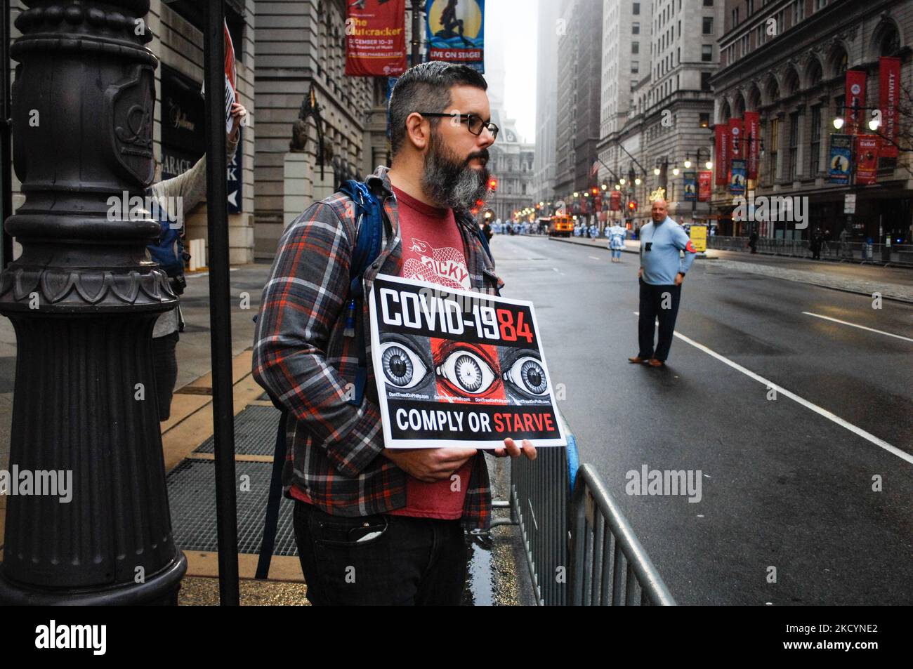 Ein Anti-Impfmandat-Protestler hält ein Zeichen, das das Mandat des Gesundheitsministeriums von Philadelphia mit George Orwells dystopischer Fiktion 1984 während der Mummer’s Parade 2022 in Philadelphia, PA, am 2. Januar 2022 vergleicht. (Foto von Cory Clark/NurPhoto) Stockfoto