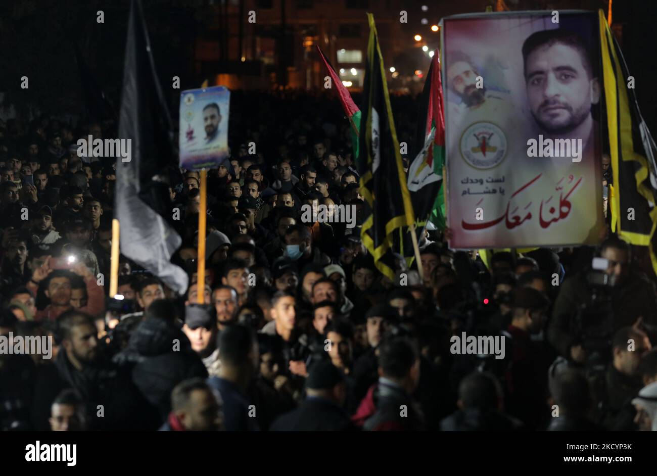 Palästinensische Demonstranten halten Fotos von Hisham Abu Hawasch, 40, der sich seit mehr als 140 Tagen in einem Hungerstreik befindet, nachdem er von Israel verhaftet und in Verwaltungshaft genommen wurde, in Gaza City, 3. Januar 2022. Verwandte von Abu Hawash sagten, dass er sich in einem kritischen Zustand in einem israelischen Krankenhaus befand. (Foto von Majdi Fathi/NurPhoto) Stockfoto