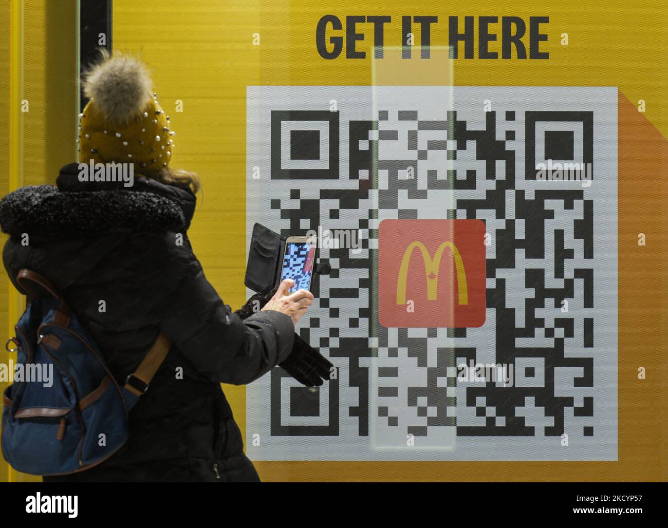 Mcdonald Code Entry Eine Frau überprüft den QR-Code mit ihrem Mobiltelefon vor einem ...