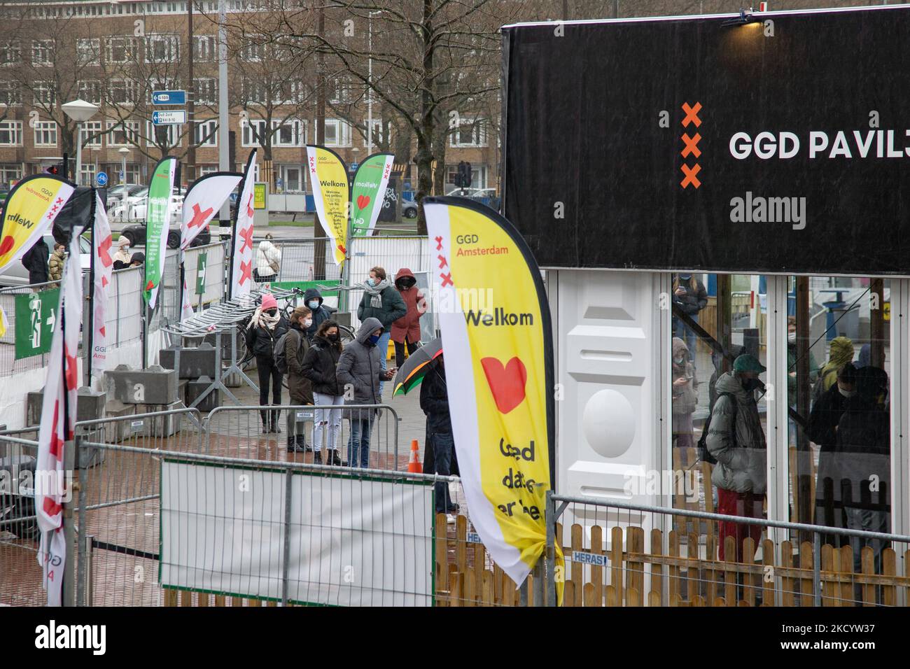 Menschen mit Gesichtsmasken warten vor einer Einrichtung des GGD Paviljoen Amsterdam Covid-19-Testzentrums, um getestet zu werden, GGD ist der städtische Gesundheitsdienst in Amsterdam Zuid. Die Niederlande waren die erste europäische Nation, die kurz vor Weihnachten während der Coronavirus-Pandemie von Covid-19 eine Sperre gegen die neue Omicron-Variante ausrief. Bars, Fitnessstudios, Friseure und alle „nicht notwendigen“ Geschäfte, Museen, öffentlichen Einrichtungen usw. waren bis mindestens Januar 14 geschlossen. Amsterdam, Niederlande am 5. Januar 2022 (Foto von Nicolas Economou/NurPhoto) Stockfoto