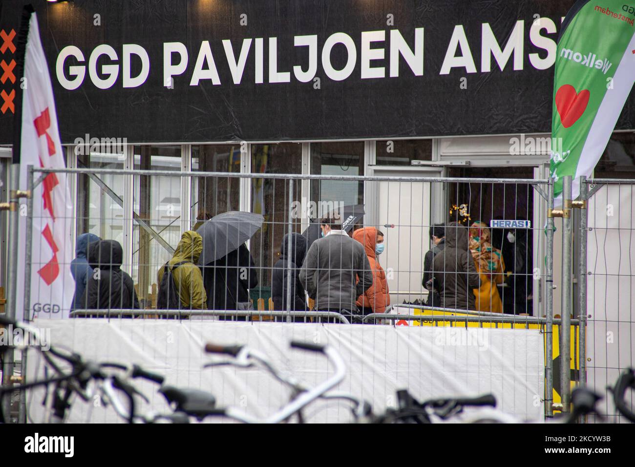 Menschen mit Gesichtsmasken warten vor einer Einrichtung des GGD Paviljoen Amsterdam Covid-19-Testzentrums, um getestet zu werden, GGD ist der städtische Gesundheitsdienst in Amsterdam Zuid. Die Niederlande waren die erste europäische Nation, die kurz vor Weihnachten während der Coronavirus-Pandemie von Covid-19 eine Sperre gegen die neue Omicron-Variante ausrief. Bars, Fitnessstudios, Friseure und alle „nicht notwendigen“ Geschäfte, Museen, öffentlichen Einrichtungen usw. waren bis mindestens Januar 14 geschlossen. Amsterdam, Niederlande am 5. Januar 2022 (Foto von Nicolas Economou/NurPhoto) Stockfoto