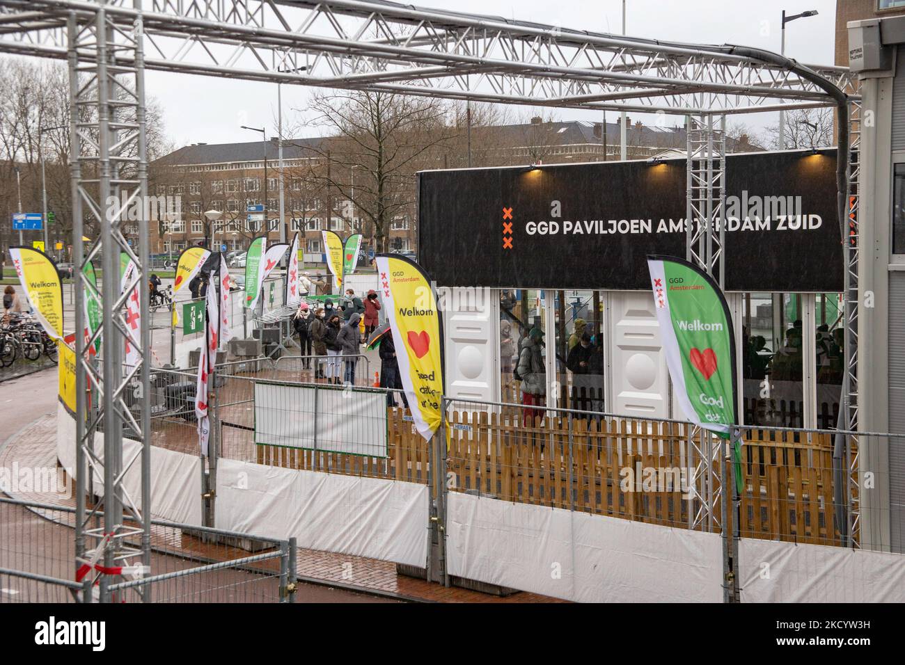 Menschen mit Gesichtsmasken warten vor einem GGD Covid-19 Testzentrum in der Reihe, um getestet zu werden, GGD ist der städtische Gesundheitsdienst in Amsterdam Zuid. Die Niederlande waren die erste europäische Nation, die kurz vor Weihnachten während der Coronavirus-Pandemie von Covid-19 eine Sperre gegen die neue Omicron-Variante ausrief. Bars, Fitnessstudios, Friseure und alle „nicht notwendigen“ Geschäfte, Museen, öffentlichen Einrichtungen usw. waren bis mindestens Januar 14 geschlossen. Amsterdam, Niederlande am 5. Januar 2022 (Foto von Nicolas Economou/NurPhoto) Stockfoto