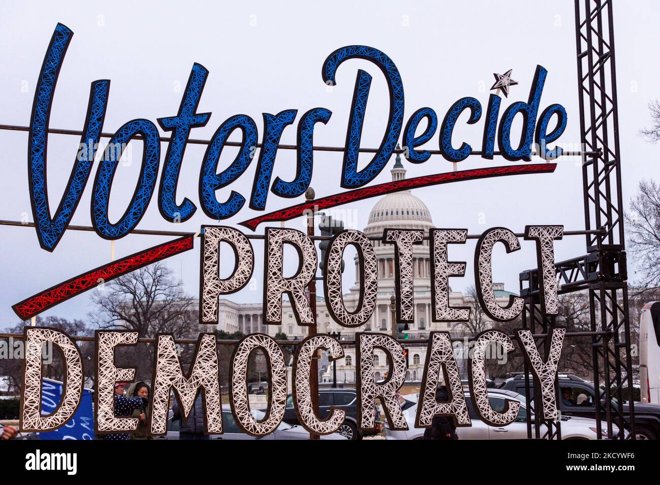 Das Kapitol steht bei einer Kerzenlichtmahnwache zur Erinnerung an den Aufstand vom 6. Januar hinter einem großen Schild. Die Veranstaltung ist eine von vielen landesweit veranstalteten Mahnwachen für Demokratie im Januar 6. Die Organisation und ihre Partner fordern vom Kongress die Annahme des John Lewis Voting Rights Advancement Act, des Freedom to Vote Act, des Protecting Our Democracy Act und der DC Statehood. (Foto von Allison Bailey/NurPhoto) Stockfoto