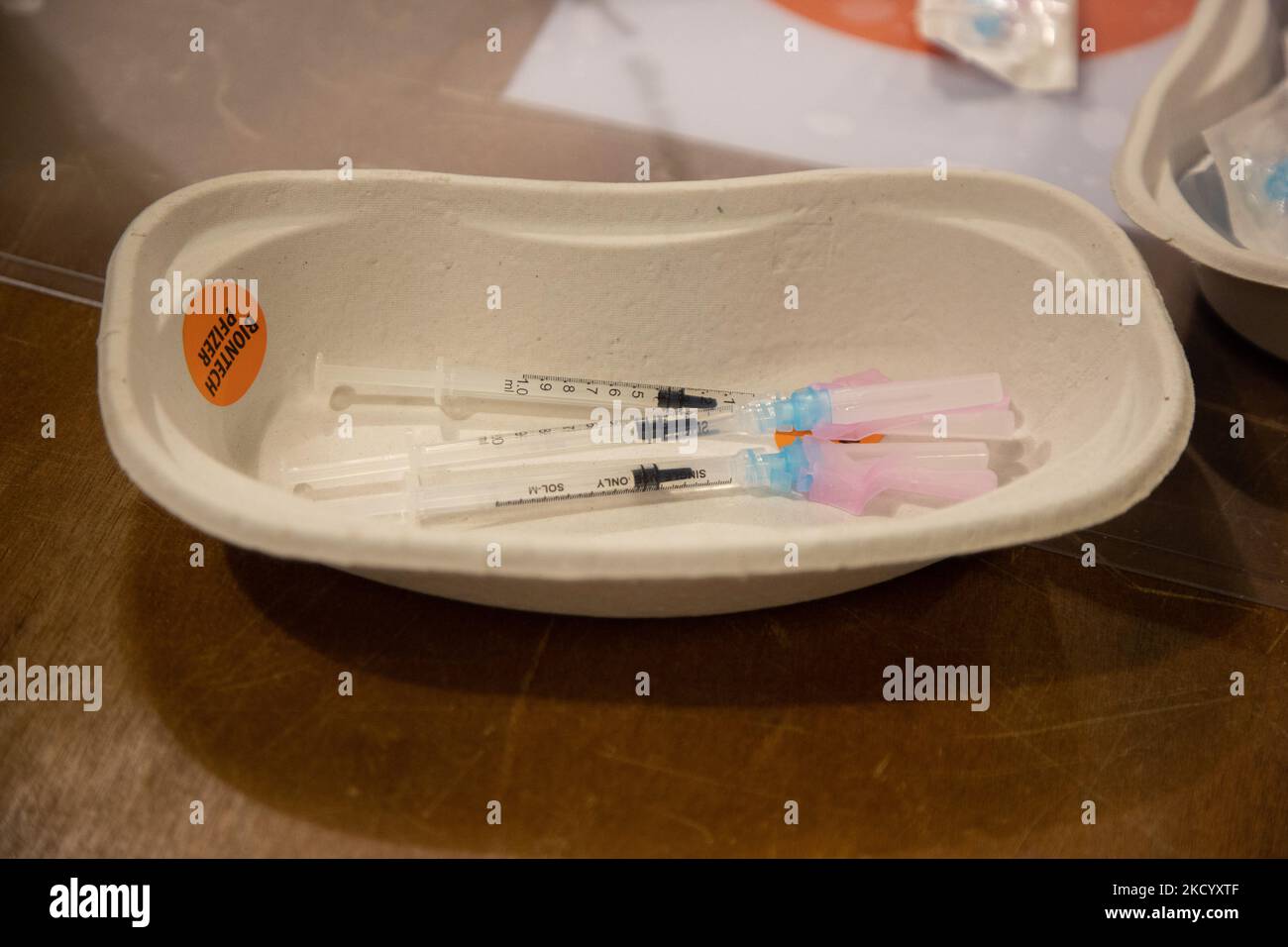 Nahaufnahme des Fläschchens mit der Aufschrift Comirnaty, mRNA usw., der Nadel und der Spritze, während eine GGD-Mitarbeiterin die Pfizer - BioNTech Covid-19-Impfstoffe vorbereitet, die sie aus der Fläschchenglasflasche zu den Spritzen im Sonderbereich des Mega-Impfzentrums in Eindhoven zieht. Die Jabs werden als Booster-Schuss verabreicht. Der dritte Dosisverstärker ist für alle in den Niederlanden verfügbar, zusätzlich zur Sperrung, da das Land gegen Ausbrüche der neuen omicron-Variante-Coronavirus-Mutation der Pandemie kämpft. Eindhoven, Niederlande am 7. Januar 2022 (Foto: Nicolas Economou/N Stockfoto