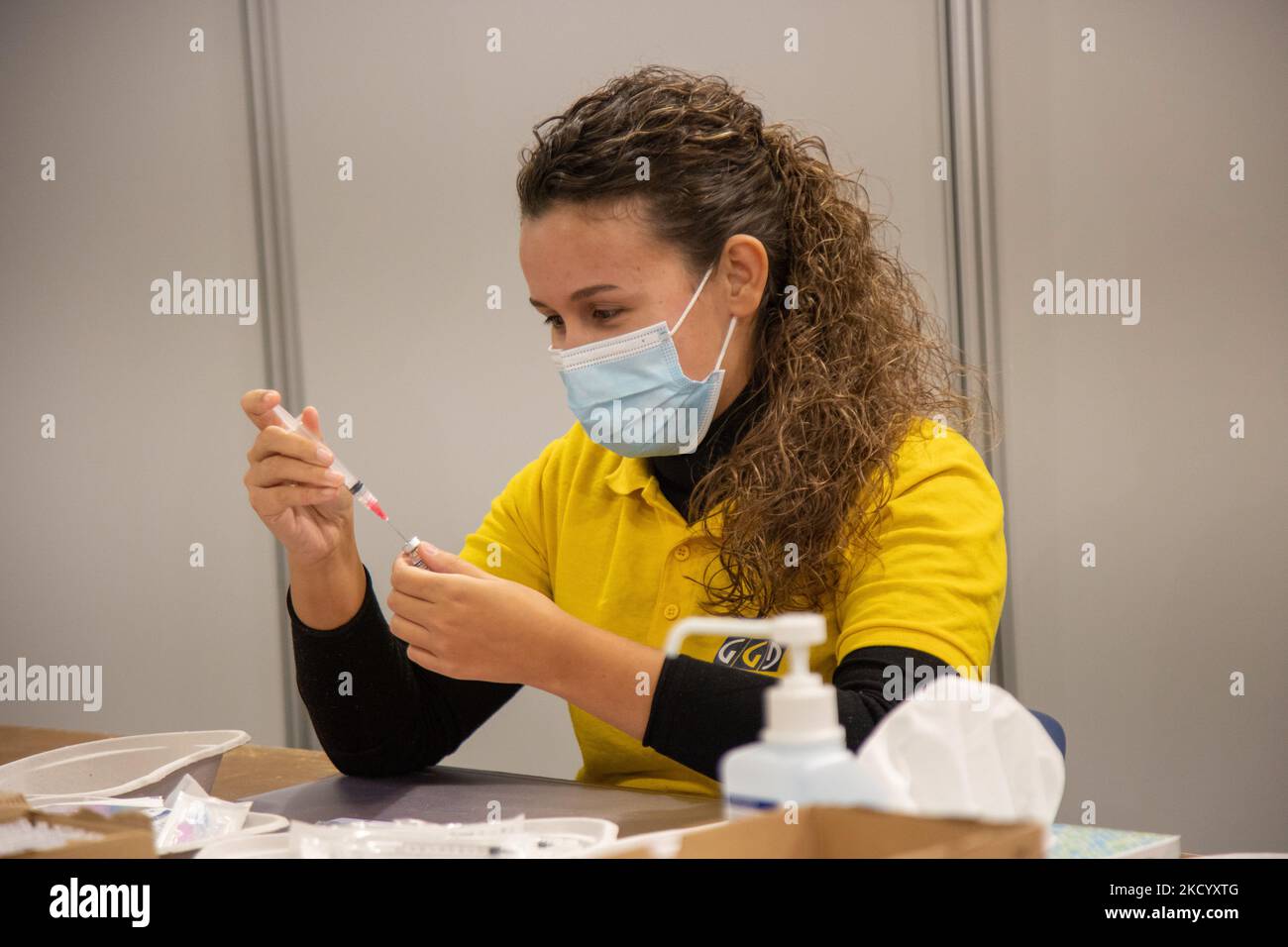 Eine GGD-Mitarbeiterin im Gesundheitswesen bereitet die Pfizer - BioNTech Covid-19-Impfstoffe vor, die sie aus der Fläschchenglasflasche zu den Spritzen im Sonderbereich des Mega-Impfzentrums in Eindhoven zieht. Die Jabs werden als Booster-Schuss verabreicht. Der dritte Dosisverstärker ist für alle in den Niederlanden verfügbar, zusätzlich zur Sperrung, da das Land gegen Ausbrüche der neuen omicron-Variante-Coronavirus-Mutation der Pandemie kämpft. Eindhoven, Niederlande am 7. Januar 2022 (Foto: Nicolas Economou/NurPhoto) Stockfoto