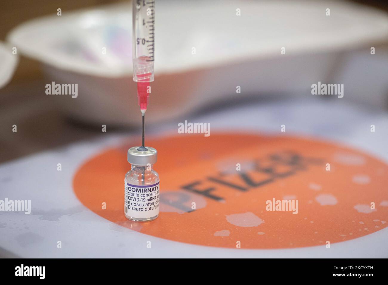 Nahaufnahme des Fläschchens mit der Aufschrift Comirnaty, mRNA usw., der Nadel und der Spritze, während eine GGD-Mitarbeiterin die Pfizer - BioNTech Covid-19-Impfstoffe vorbereitet, die sie aus der Fläschchenglasflasche zu den Spritzen im Sonderbereich des Mega-Impfzentrums in Eindhoven zieht. Die Jabs werden als Booster-Schuss verabreicht. Der dritte Dosisverstärker ist für alle in den Niederlanden verfügbar, zusätzlich zur Sperrung, da das Land gegen Ausbrüche der neuen omicron-Variante-Coronavirus-Mutation der Pandemie kämpft. Eindhoven, Niederlande am 7. Januar 2022 (Foto: Nicolas Economou/N Stockfoto