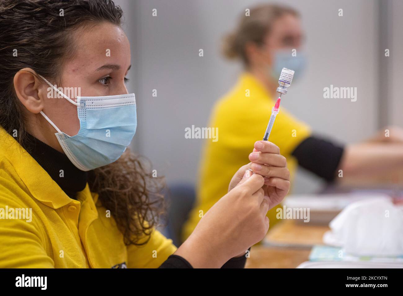 Eine GGD-Mitarbeiterin im Gesundheitswesen bereitet die Pfizer - BioNTech Covid-19-Impfstoffe vor, die sie aus der Fläschchenglasflasche zu den Spritzen im Sonderbereich des Mega-Impfzentrums in Eindhoven zieht. Die Jabs werden als Booster-Schuss verabreicht. Der dritte Dosisverstärker ist für alle in den Niederlanden verfügbar, zusätzlich zur Sperrung, da das Land gegen Ausbrüche der neuen omicron-Variante-Coronavirus-Mutation der Pandemie kämpft. Eindhoven, Niederlande am 7. Januar 2022 (Foto: Nicolas Economou/NurPhoto) Stockfoto