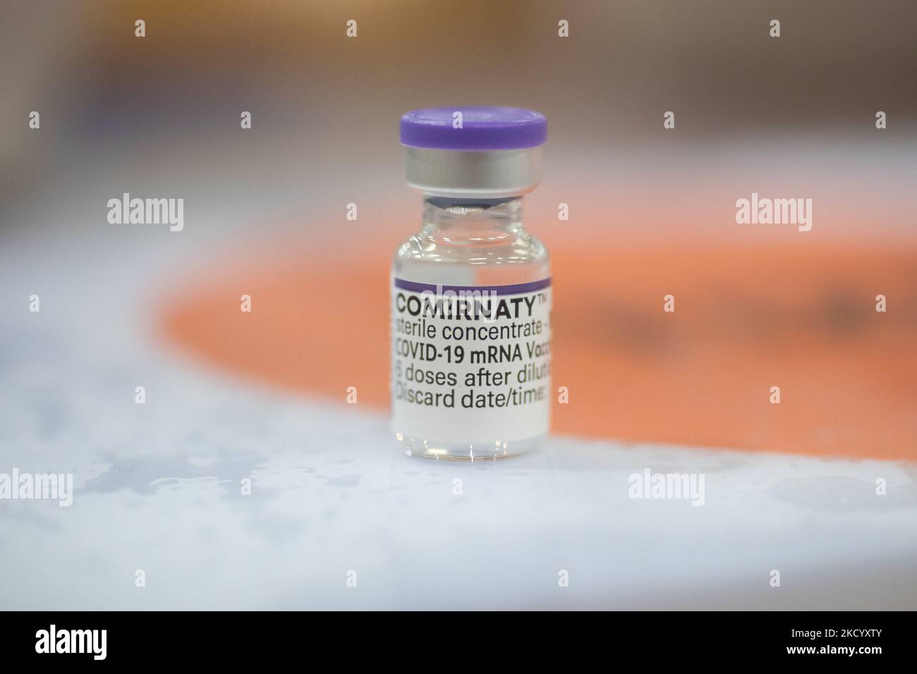 Nahaufnahme des Fläschchens mit der Aufschrift Comirnaty, mRNA usw., der Nadel und der Spritze, während eine GGD-Mitarbeiterin die Pfizer - BioNTech Covid-19-Impfstoffe vorbereitet, die sie aus der Fläschchenglasflasche zu den Spritzen im Sonderbereich des Mega-Impfzentrums in Eindhoven zieht. Die Jabs werden als Booster-Schuss verabreicht. Der dritte Dosisverstärker ist für alle in den Niederlanden verfügbar, zusätzlich zur Sperrung, da das Land gegen Ausbrüche der neuen omicron-Variante-Coronavirus-Mutation der Pandemie kämpft. Eindhoven, Niederlande am 7. Januar 2022 (Foto: Nicolas Economou/N Stockfoto