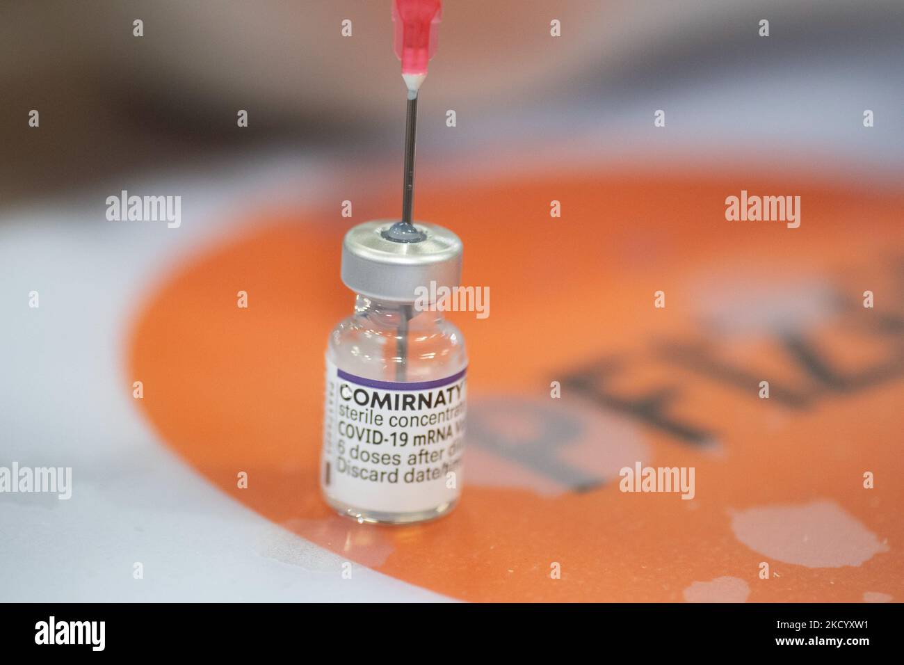 Nahaufnahme des Fläschchens mit der Aufschrift Comirnaty, mRNA usw., der Nadel und der Spritze, während eine GGD-Mitarbeiterin die Pfizer - BioNTech Covid-19-Impfstoffe vorbereitet, die sie aus der Fläschchenglasflasche zu den Spritzen im Sonderbereich des Mega-Impfzentrums in Eindhoven zieht. Die Jabs werden als Booster-Schuss verabreicht. Der dritte Dosisverstärker ist für alle in den Niederlanden verfügbar, zusätzlich zur Sperrung, da das Land gegen Ausbrüche der neuen omicron-Variante-Coronavirus-Mutation der Pandemie kämpft. Eindhoven, Niederlande am 7. Januar 2022 (Foto: Nicolas Economou/N Stockfoto