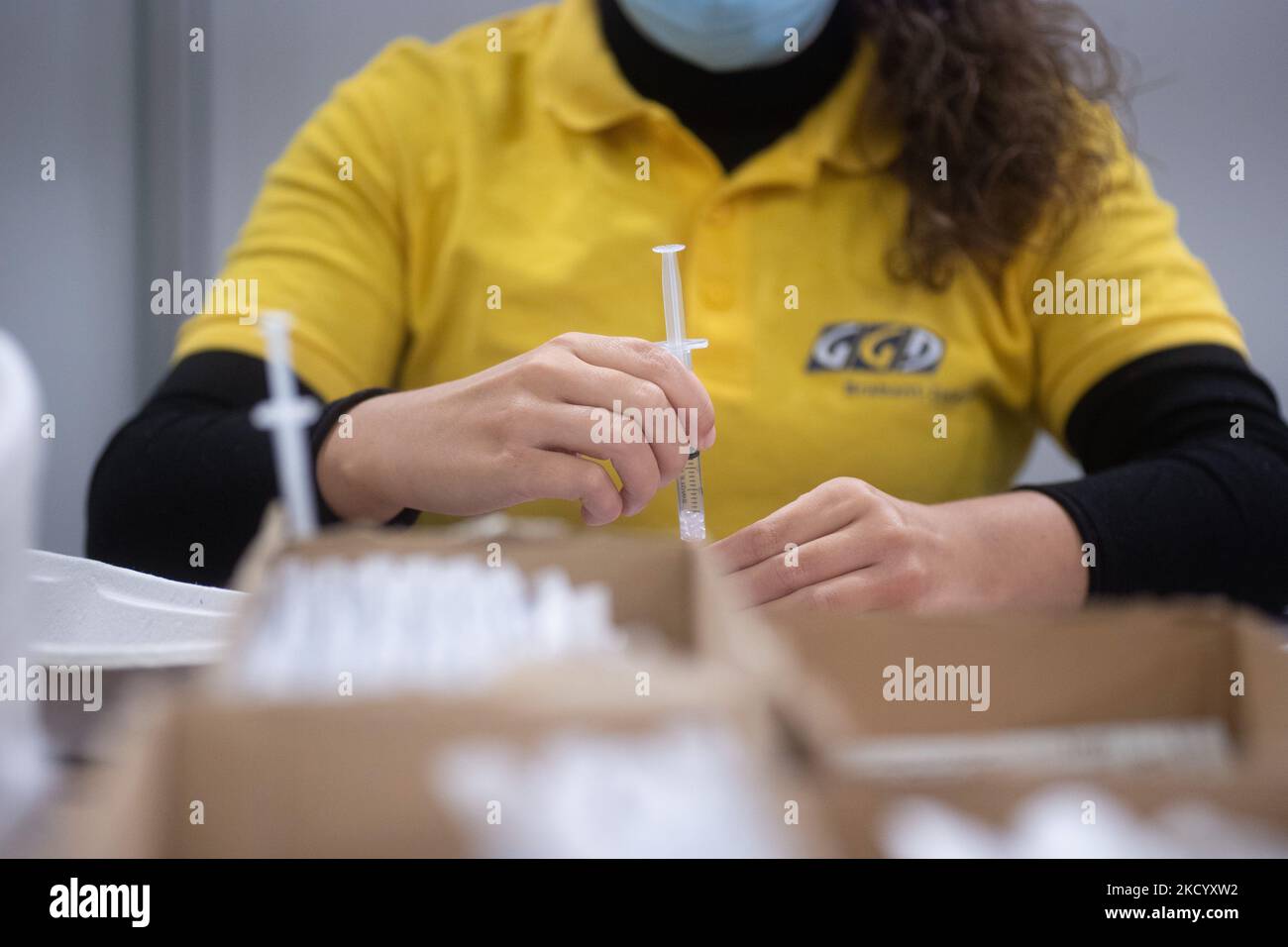 Eine GGD-Mitarbeiterin im Gesundheitswesen bereitet die Pfizer - BioNTech Covid-19-Impfstoffe vor, die sie aus der Fläschchenglasflasche zu den Spritzen im Sonderbereich des Mega-Impfzentrums in Eindhoven zieht. Die Jabs werden als Booster-Schuss verabreicht. Der dritte Dosisverstärker ist für alle in den Niederlanden verfügbar, zusätzlich zur Sperrung, da das Land gegen Ausbrüche der neuen omicron-Variante-Coronavirus-Mutation der Pandemie kämpft. Eindhoven, Niederlande am 7. Januar 2022 (Foto: Nicolas Economou/NurPhoto) Stockfoto