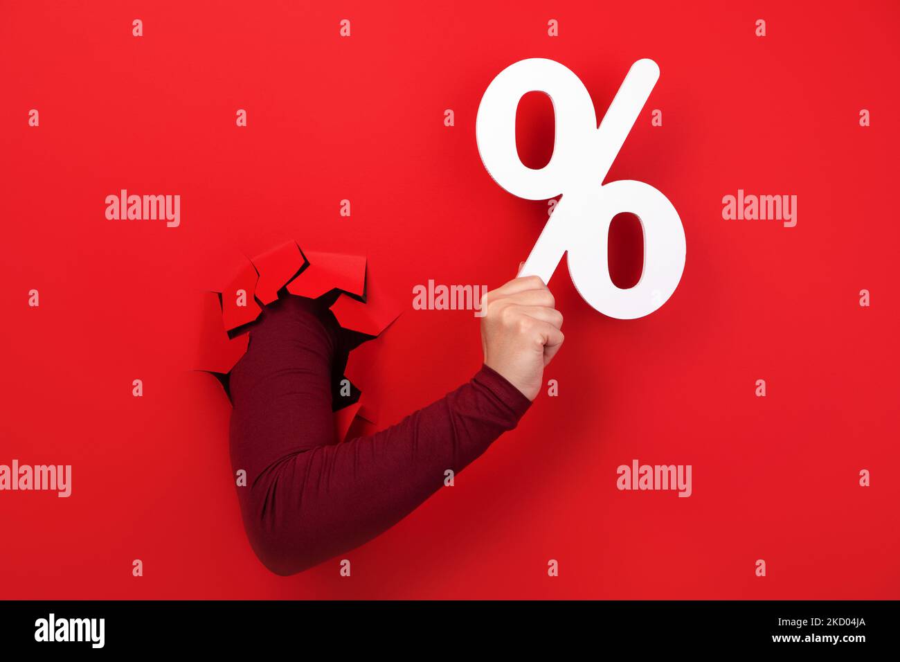 Hand hält Prozentzeichen über rotem Hintergrund Stockfoto
