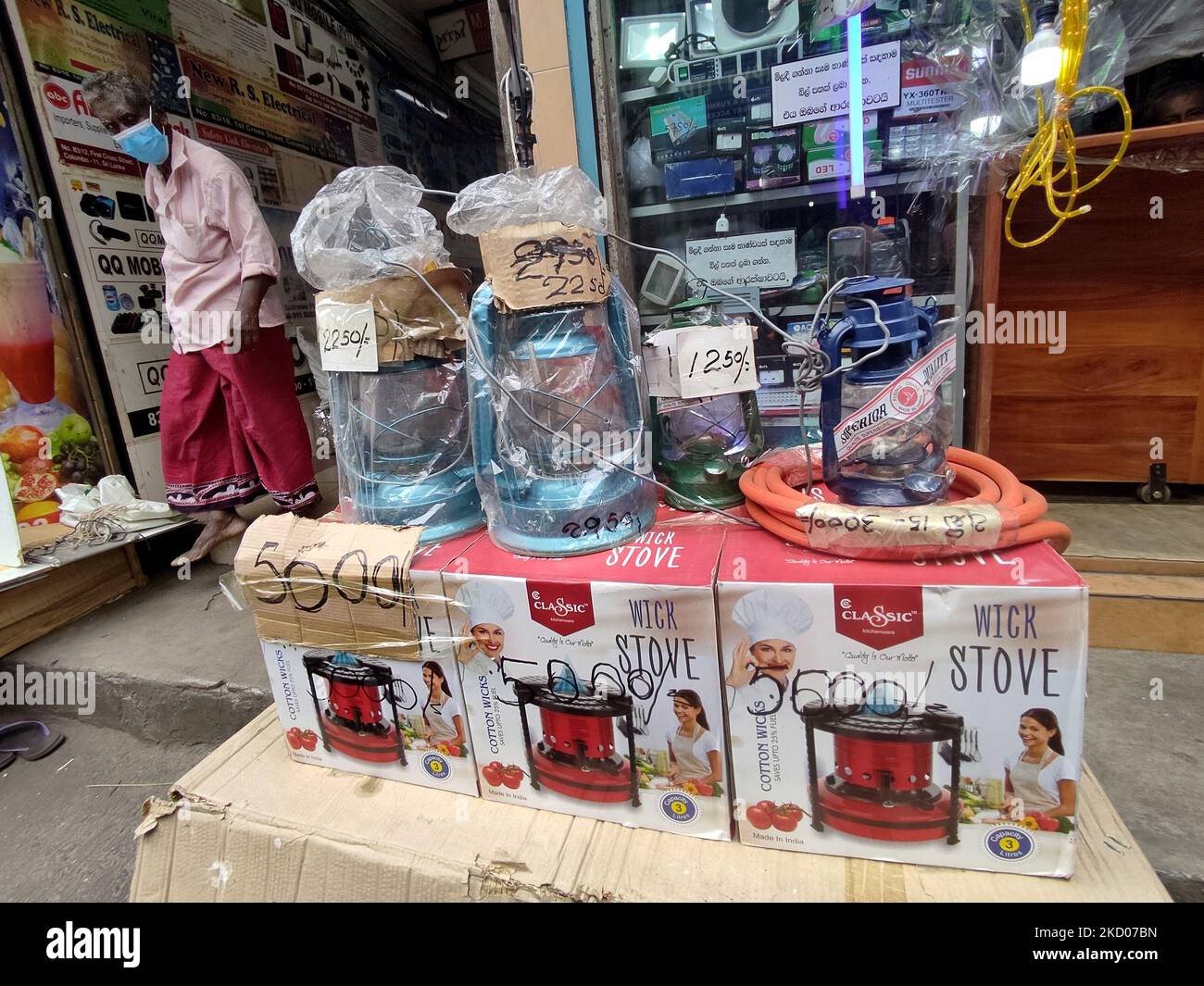 Ein Mann aus Sri Lanka, der eine Gesichtsmask trägt, sieht sich Kerosinlampen und Kerosinherde an, die zum Verkauf auf einem lokalen Markt in Colombo, Sri Lanka, zu Preisen zwischen 11 US-Dollar und 27 US-Dollar (1 USD = 202 LKR ) gehalten werden. 10. Januar 2022. Laut Indian Express könnte Sri Lanka in der dritten Januarwoche mit einem Mangel an Treibstoff rechnen, warnte Energieminister Udaya Gammanpila am Freitag(7), als er die srilankische Zentralbank einforderte, einzuspringen und die für Importe erforderliche Fremdwährung einzupumpen. (Foto von Tharaka Basnayaka/NurPhoto) Stockfoto