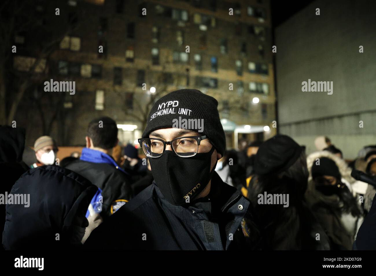 Ein NYPD-Beamter steht während einer Mahnwache vor einem Hochhaus, in dem am 11. Januar 2022 im Stadtteil Fordham Heights in der Bronx in New York City, USA, siebzehn Personen, darunter acht Kinder, bei einem Brand starben. Zu Beginn der Untersuchung wurde festgestellt, dass mehrere Raumheizgeräte tagelang in Betrieb waren, eine davon zündet an. Zur Todesrate trug eine nicht automatisch schließenden, defekten Tür bei, die tödlich giftigen Rauch in das Gebäude eindrang. (Foto von John Lamparski/NurPhoto) Stockfoto