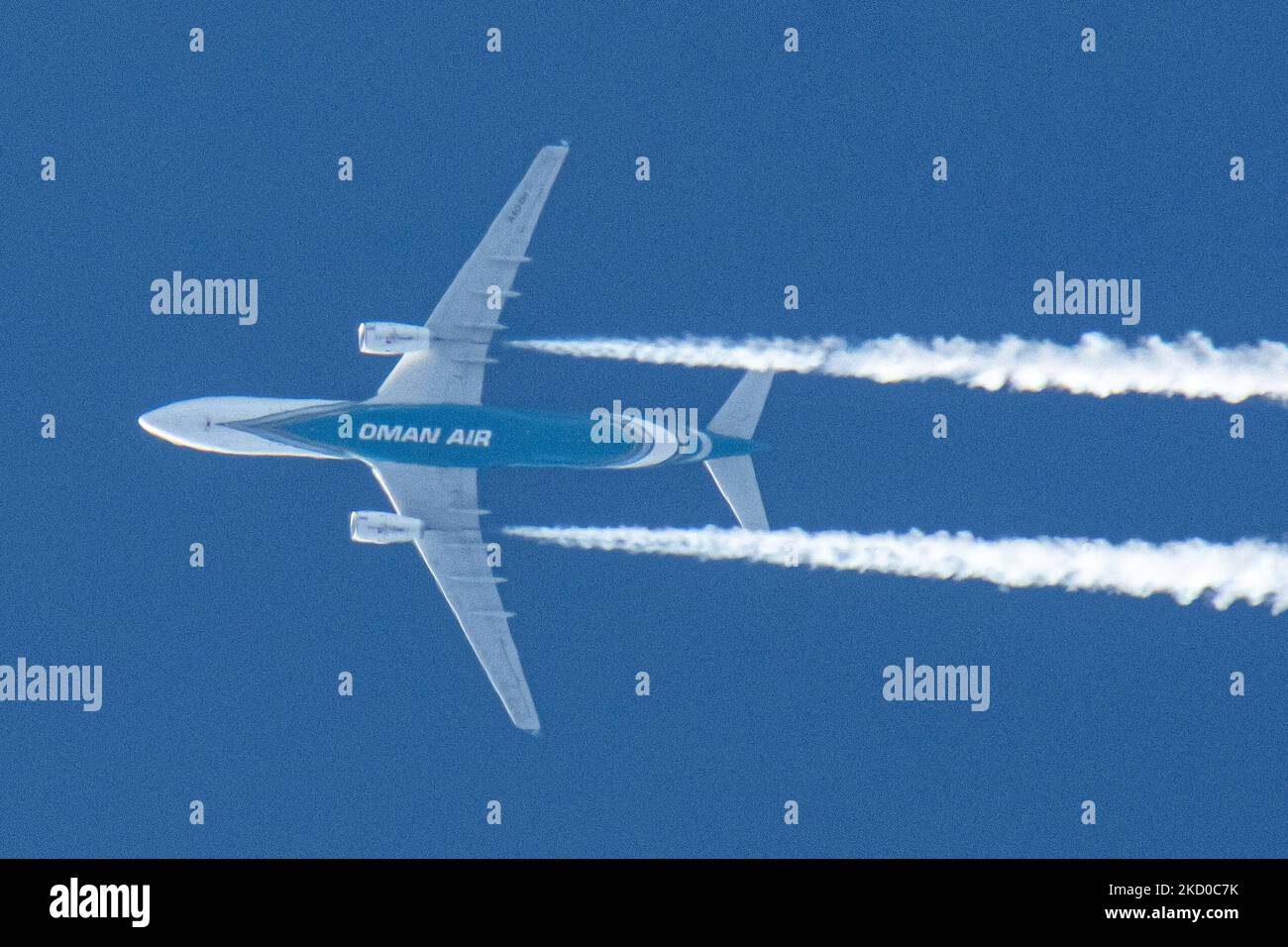 Oman Air Airbus A330-Großraumflugzeuge, wie sie bei einem klaren blauen Himmel an einem 40,000 Fuß langen Tag in der niederländischen Stadt Eindhoven fliegen. Die Fluggesellschaft ist die nationale Fluggesellschaft des Sultanats Oman, einem Land an der südöstlichen Küste der Arabischen Halbinsel. Die OMAN AIR Logo Inschrift am Bauch des blauen Rumpfes des Überflugzeugs ist sichtbar. Das überfliegende Flugzeug fährt von der Hauptstadt Muscat nach London und hinterlässt einen weißen Kondensstreifen, der als Kondensstreifen bekannt ist. Die Luftfahrtindustrie und der Personenverkehr stehen mit dem Coronavirus pa Covid-19 in einer schwierigen Phase Stockfoto