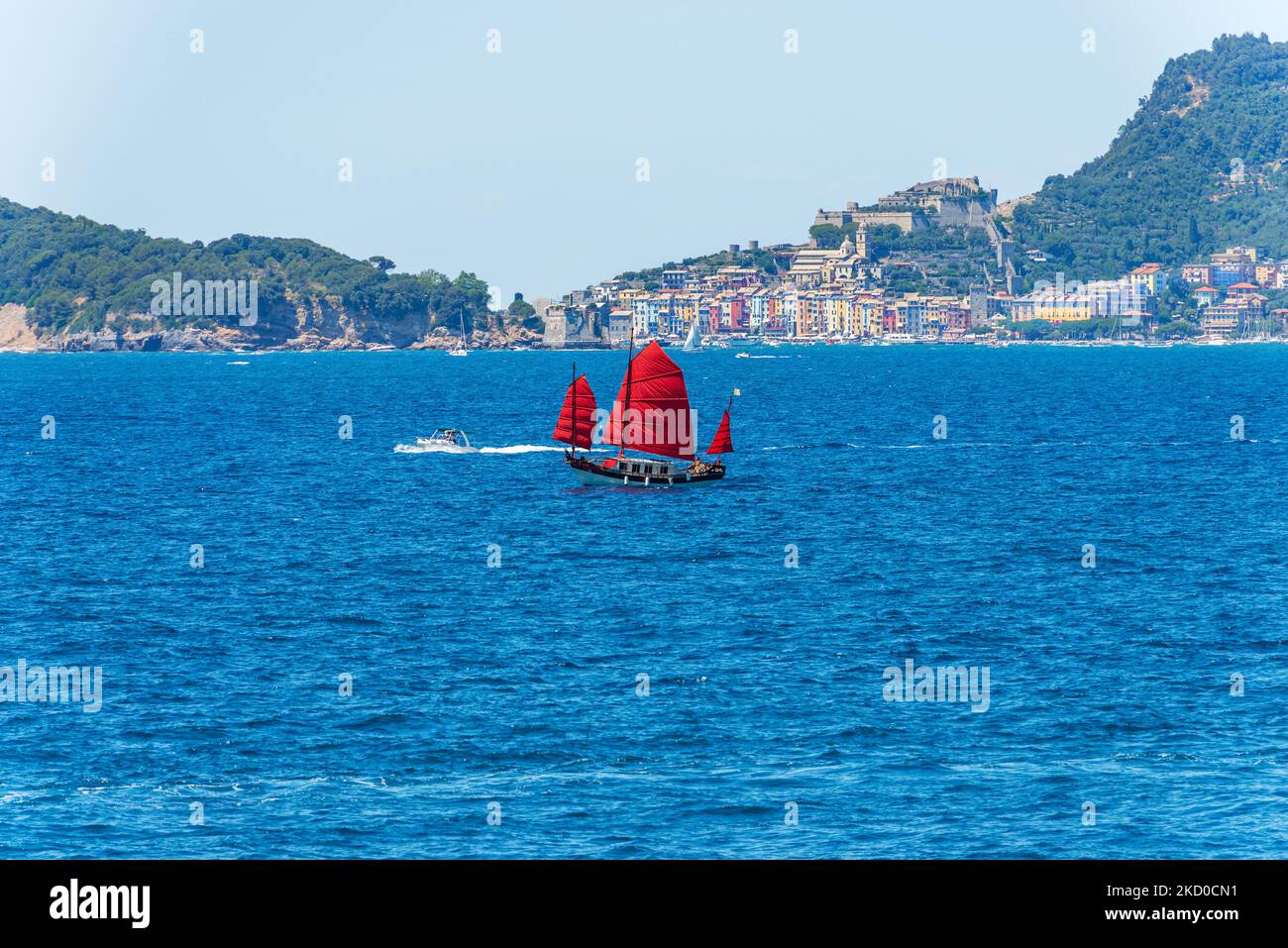 Altes Segelboot mit drei roten Segeln im blauen Mittelmeer vor der berühmten Stadt Porto Venere oder Portovenere, UNESCO-Weltkulturerbe, G Stockfoto