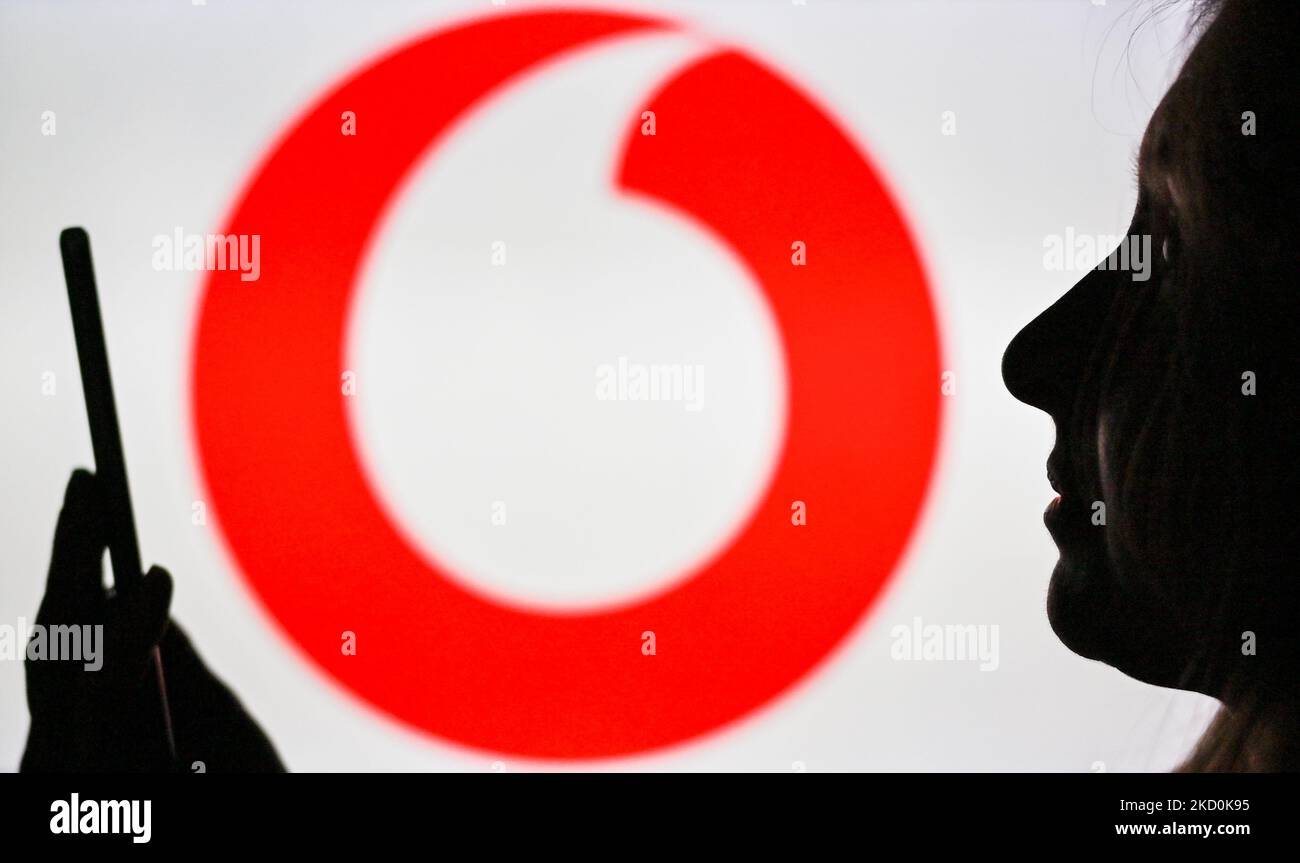 Ein Bild einer Frau, die ein Mobiltelefon vor das Vodafone-Logo hält, das auf einem Computerbildschirm angezeigt wird. Am Dienstag, den 12. Januar 2021, Kanada. (Foto von Artur Widak/NurPhoto) Stockfoto