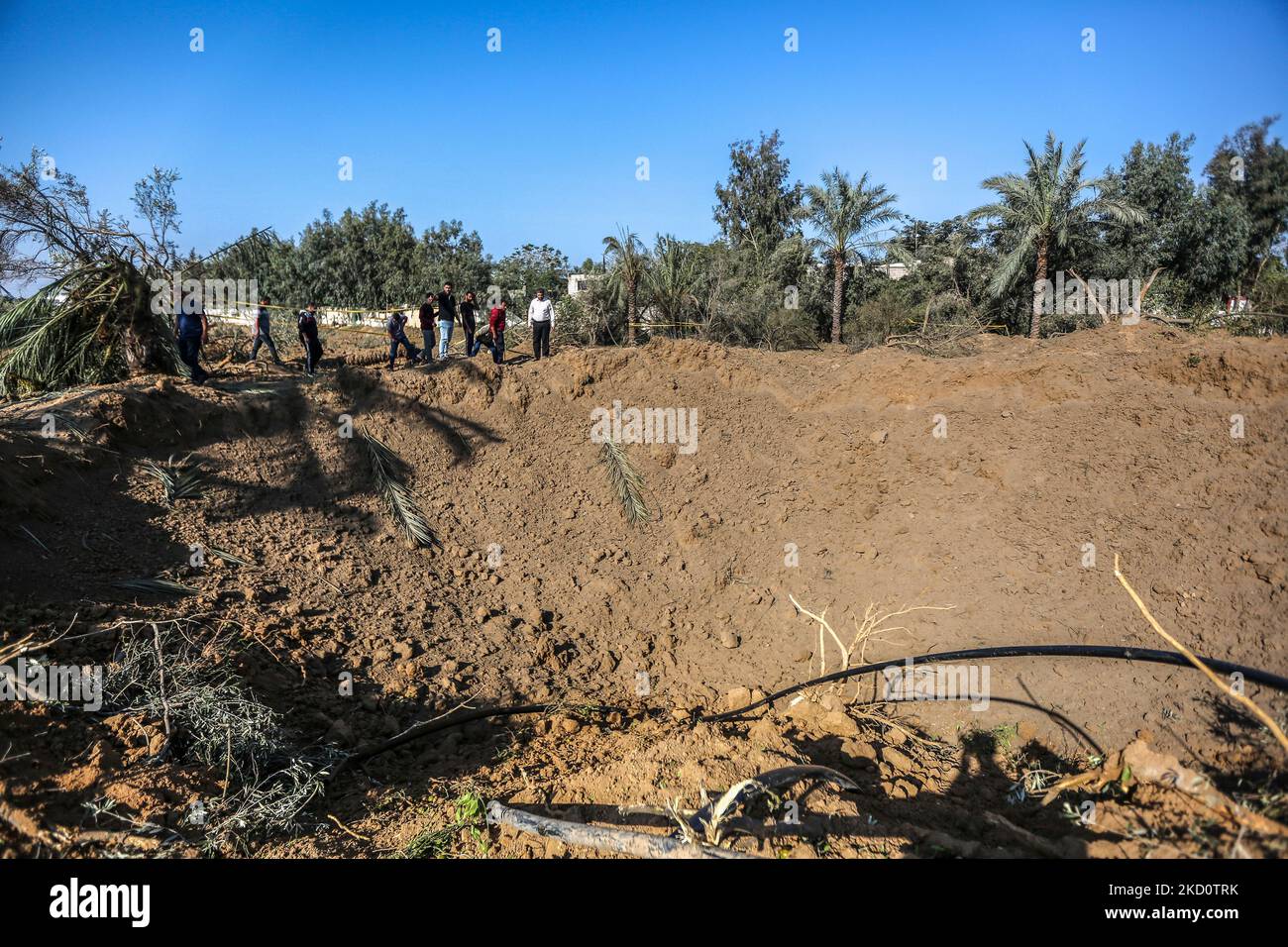 Gaza, Palästina. 04.. November 2022. Palästinenser stehen neben einem Krater in der Nähe eines Hamas-Militärstandorts, das von israelischen Luftangriffen im zentralen Gazastreifen als Reaktion auf den Raketenbeschuss aus dem Gazastreifen auf Israel anvisiert wird. Kredit: SOPA Images Limited/Alamy Live Nachrichten Stockfoto