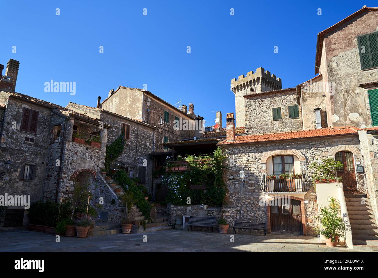 Gepflasterter Platz mit alten Steingebäuden in Capalbio, Italia Stockfoto