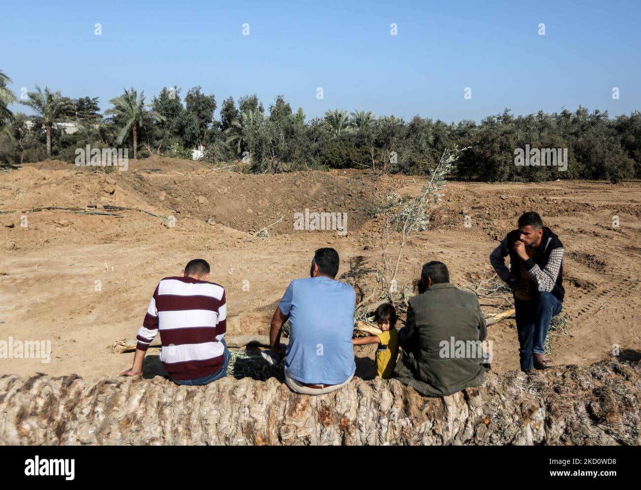 Gaza, Palästina. 04.. November 2022. Palästinenser sitzen in der Nähe eines Krater in der Nähe eines militärischen Postens der Hamas, der von israelischen Luftangriffen im zentralen Gazastreifen als Reaktion auf den Raketenbeschuss aus dem Gazastreifen auf Israel anvisiert wird. Kredit: SOPA Images Limited/Alamy Live Nachrichten Stockfoto