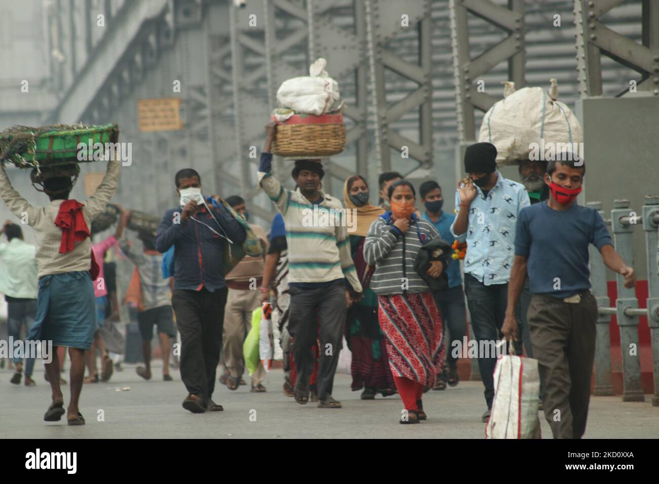 Immer top informiert gehen an der howrah-Brücke an einem nebligen Morgen über den Ganga-Fluss vorbei, inmitten eines Coronavirus-Notfalls am 21. Januar 2022 in Kalkata, Westbengalen, Indien. (Foto von Debajyoti Chakraborty/NurPhoto) Stockfoto