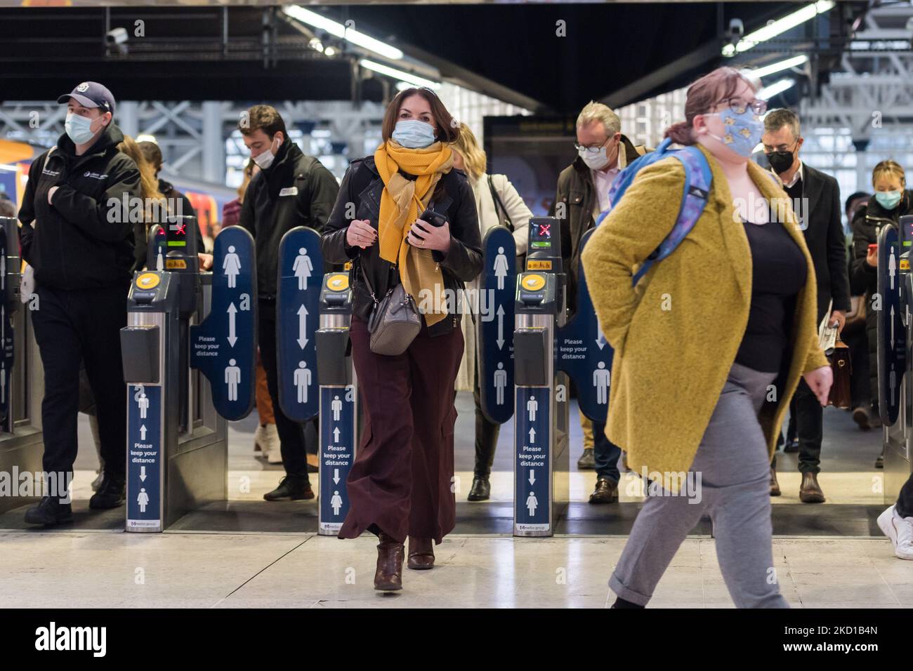 LONDON, VEREINIGTES KÖNIGREICH - 27. JANUAR 2022: Pendler, einige davon tragen weiterhin Gesichtsmasken, kommen während der morgendlichen Hauptverkehrszeit am Bahnhof Waterloo an, da die in England verhängten Plan-B-Beschränkungen, um die Ausbreitung der Omicron-Variante zu verlangsamen, am 27. Januar 2022 in London, England, zu Ende gegangen sind. Ab heute sind Gesichtsbedeckungen in Geschäften und öffentlichen Verkehrsmitteln in England nicht mehr obligatorisch, und Impfstoffzertifikate sind nicht mehr erforderlich, um große Veranstaltungsorte zu betreten. (Foto von Wiktor Szymanowicz/NurPhoto) Stockfoto
