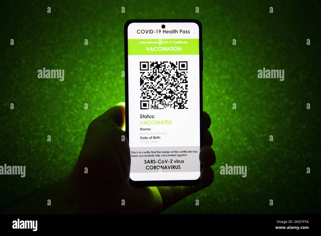 COVID Green Pass-Impfpass - Foto-Illustration einer Hand mit einem Telefon und dem Display des Mobiltelefons mit einem International COVID Green Pass und dunkelgrünem Hintergrund, einem digitalen Covid-19-Symbol-Impfpass mit einem QR, einem internationalen Impfpass oder einem Gesundheitsausweis. Foto zum Thema gefälschte QR-Impfzertifikate. Derzeit breitet sich die Pandemie auf der fünften Welle des Coronavirus aus, wobei die omicron-Mutation die dominante Variante ist. Eindhoven, Niederlande am 29. Januar 2022 (Foto: Nicolas Economou/NurPhoto) Stockfoto