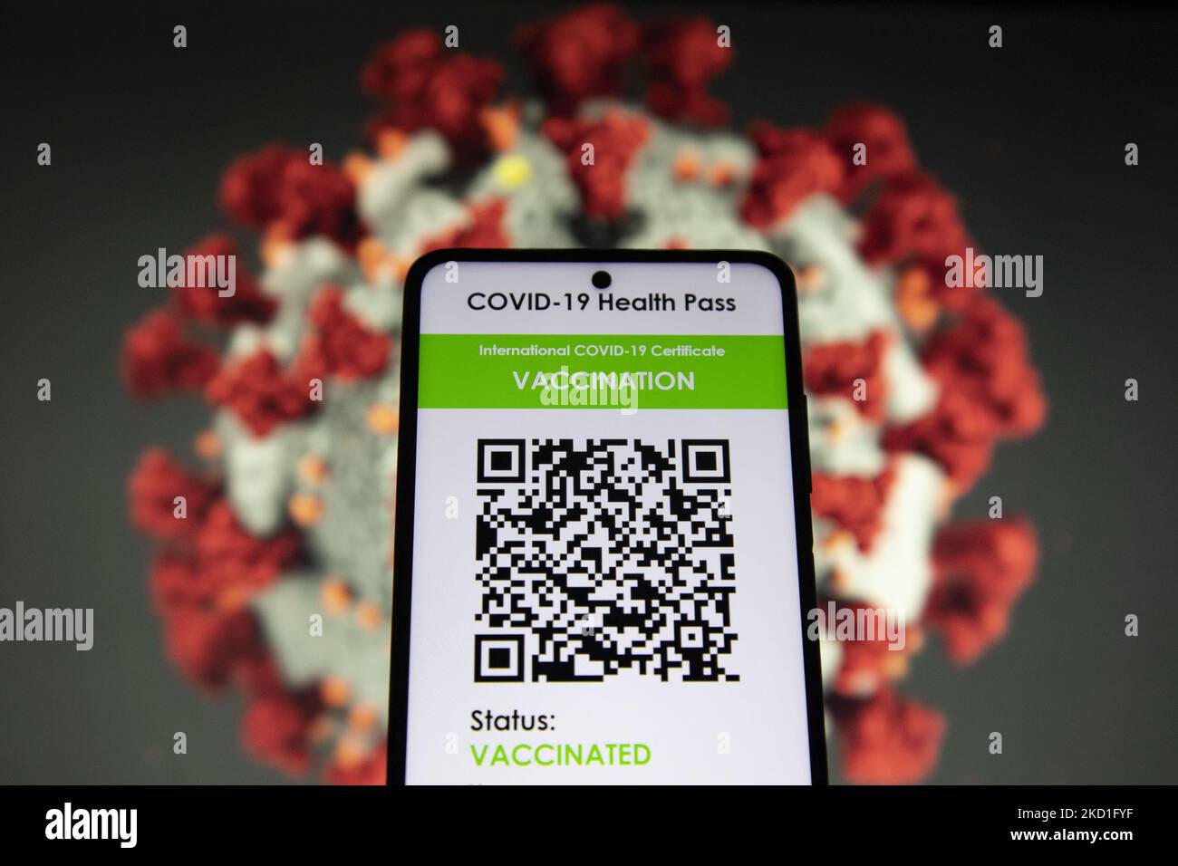 COVID Green Pass Impfpass - Foto-Illustration eines Displays eines Mobiltelefons mit einem International COVID Symbol Green Pass und einer Coronavirus-Illustration auf dem Bildschirm im Hintergrund. Der digitale Covid-19-Impfpass mit QR, einem internationalen Impfpass oder Gesundheitsausweis. Foto zum Thema gefälschte QR-Impfzertifikate. Derzeit breitet sich die Pandemie auf der fünften Welle des Coronavirus aus, wobei die omicron-Mutation die dominante Variante ist. Eindhoven, Niederlande am 29. Januar 2022 (Foto: Nicolas Economou/NurPhoto) Stockfoto