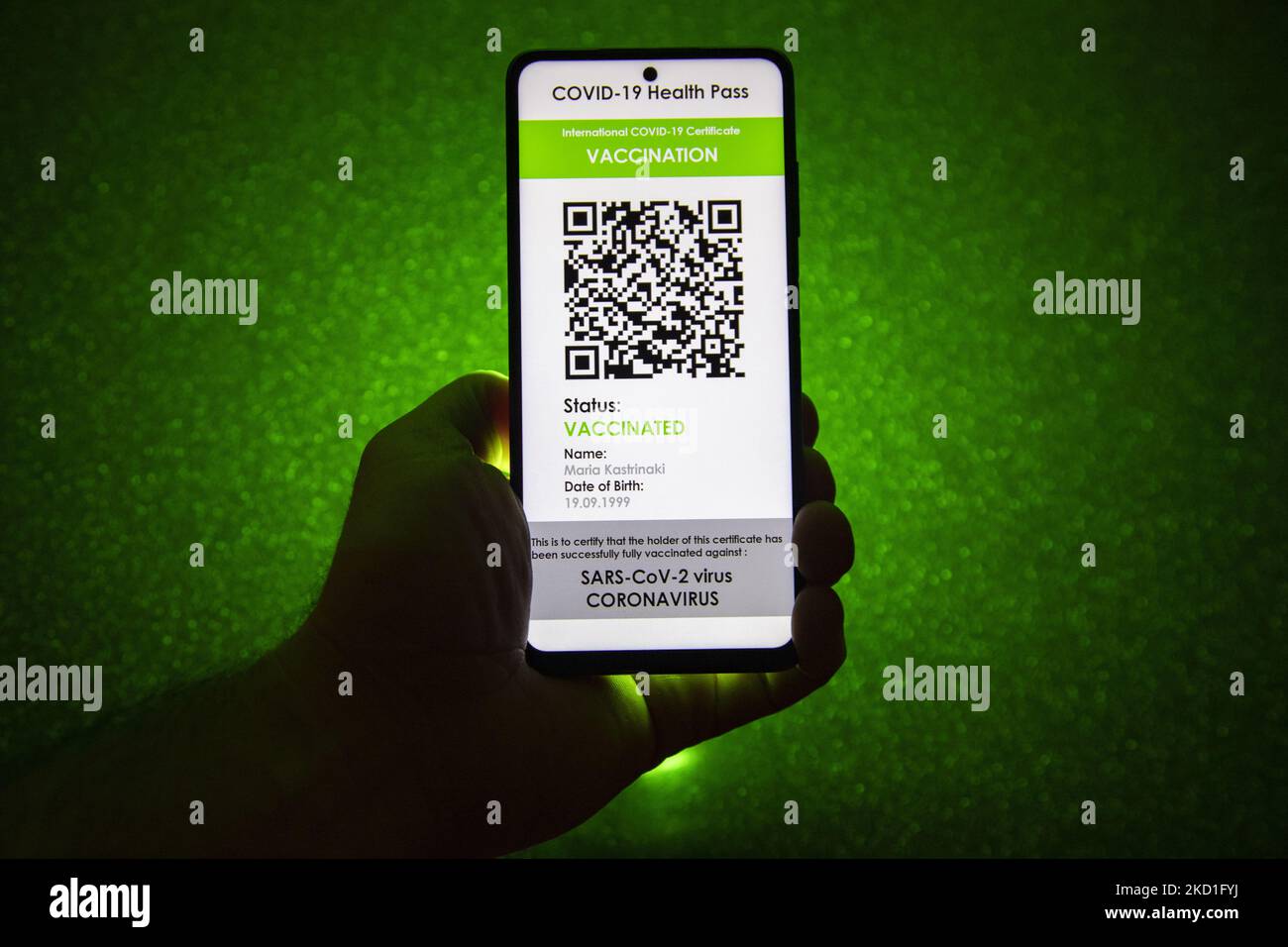 COVID Green Pass-Impfpass - Foto-Illustration einer Hand mit einem Telefon und dem Display des Mobiltelefons mit einem International COVID Green Pass und dunkelgrünem Hintergrund, einem digitalen Covid-19-Symbol-Impfpass mit einem QR, einem internationalen Impfpass oder einem Gesundheitsausweis. Foto zum Thema gefälschte QR-Impfzertifikate. Derzeit breitet sich die Pandemie auf der fünften Welle des Coronavirus aus, wobei die omicron-Mutation die dominante Variante ist. Eindhoven, Niederlande am 29. Januar 2022 (Foto: Nicolas Economou/NurPhoto) Stockfoto