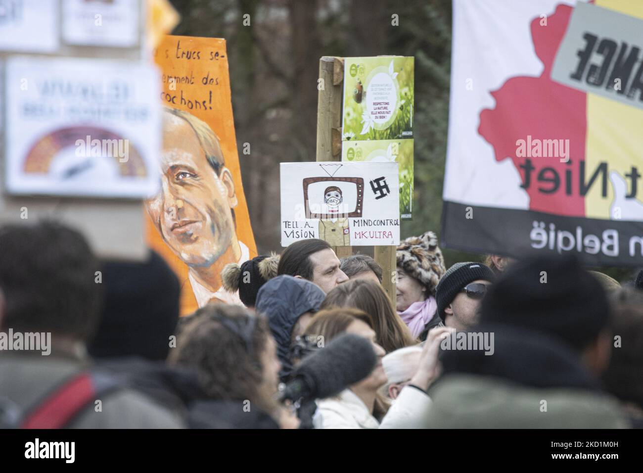 Nahaufnahme eines Spruchbanners mit dem Nazi-Symbol Hakenkreuz und der Phrase Mindcontrol mit einer Person im Fernseher, die eine Gesichtsmask mit dem Wort OBEY trägt. Protest gegen die Regierung und COVID-Maßnahmen in der belgischen Hauptstadt Brüssel. Die Demonstranten marschierten vom Nordbahnhof durch die Stadt zum Atomium, einem Wahrzeichen der Stadt, durch das Viertel Laeken. Nach Angaben der lokalen Medien versammelten sich an diesem Sonntag nur 1600 Menschen. Die Demonstration forderte die Entfernung der belgischen Regierung aufgrund der Pandemiemaßnahmen von Covid, wie der obligatorischen Impfung, der Covid Stockfoto