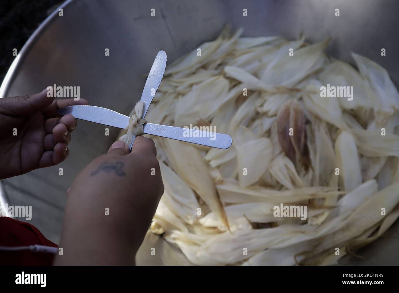 Segnung von Maisschalen mit zwei Messern in Form eines Kreuzes für die Zubereitung von Tamales, die von den Bewohnern von San Francisco Culhuacán in Mexiko-Stadt anlässlich des Candlemas-Tages verwendet werden, der die Zeit feiert, die den Zyklus der Weihnachtsfeierlichkeiten in der katholischen Kirche schließt. Das Tamale (aus dem Nahuatl Tamalli, was bedeutet, verpackt) ist ein mexikanisches Essen aus Mais, gefüllt mit verschiedenen Zutaten, gekocht in einem Paket von Gemüseblättern, die aus Mais, Kochbananen, Schilf, Chilaca oder Papatla hergestellt werden können. (Foto von Gerardo Vieyra/NurPhoto) Stockfoto