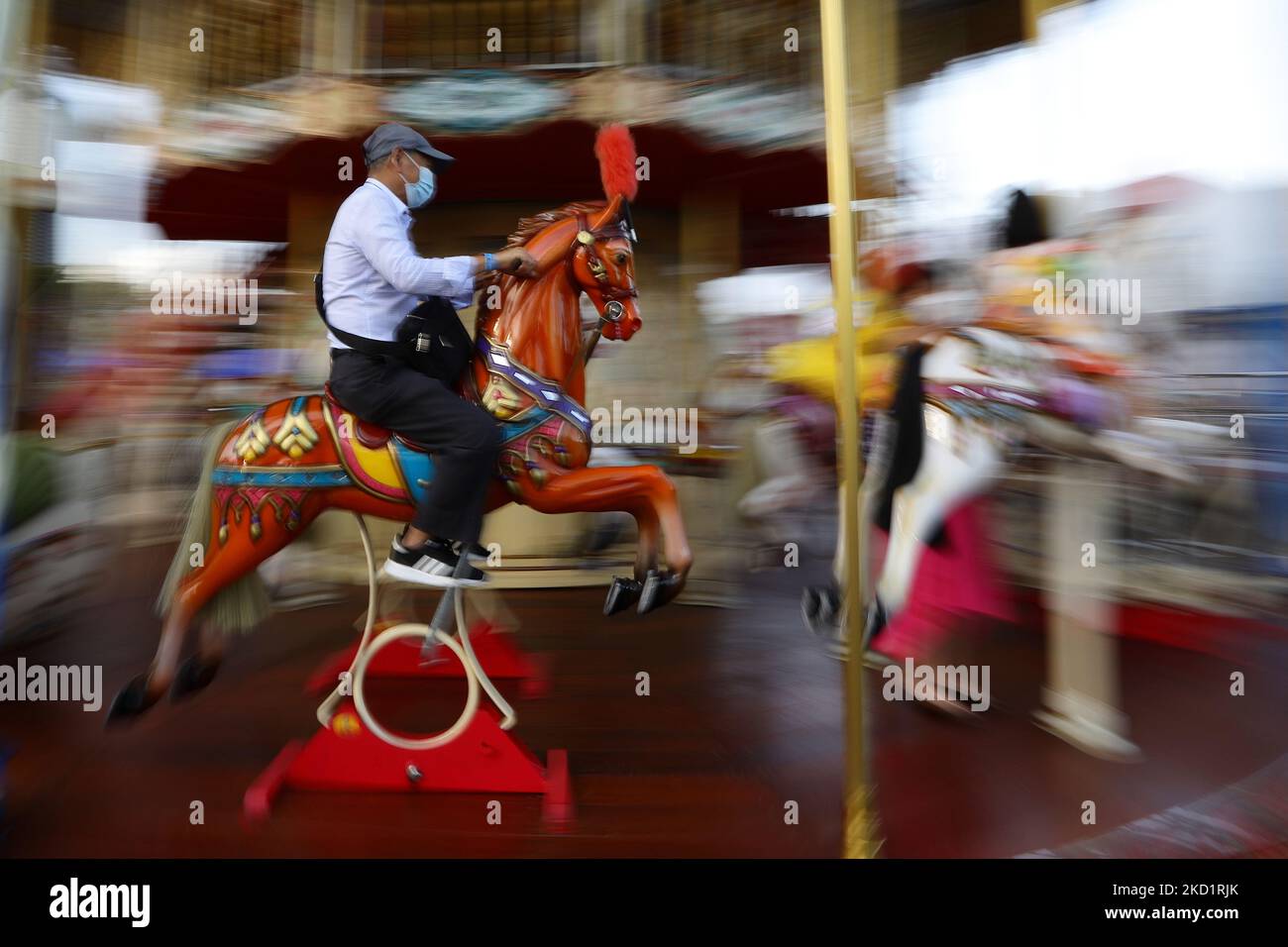 Ein Mann mit Schutzmaske reitet während des River Hongbao Festivals, das im Rahmen der chinesischen Neujahrsfeier in Gardens by the Bay am 3. Februar 2022 in Singapur stattfand, ein Karussell. (Foto von Suhaimi Abdullah/NurPhoto) Stockfoto