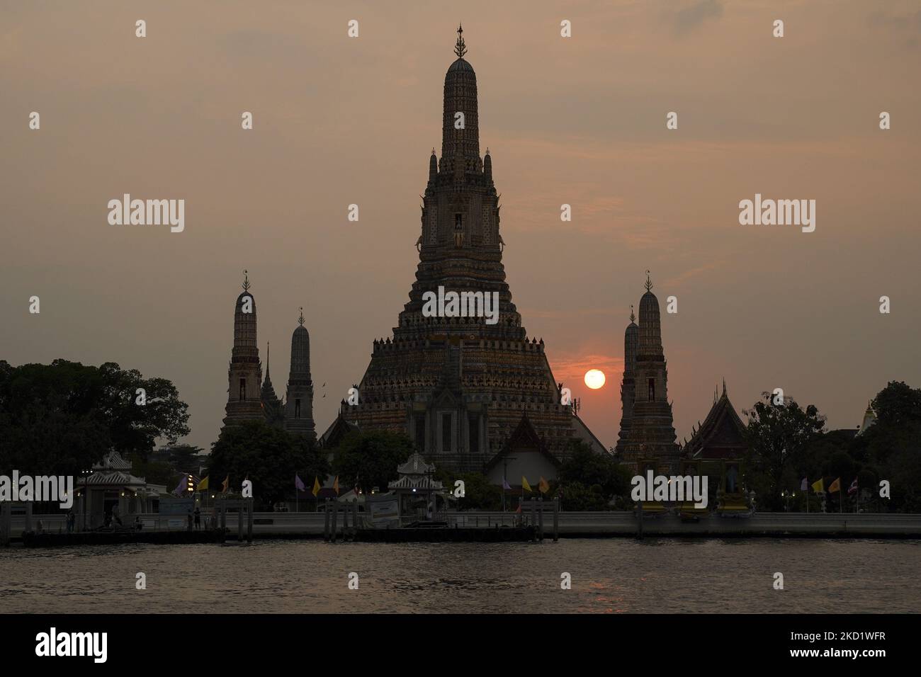 Die Sonne untergeht hinter dem Stupa des buddhistischen Tempels Wat Arun oder dem 'Tempel der Morgenröte', von der anderen Seite des Chao Phraya Flusses in Bangkok, Thailand, gesehen, 05. Februar 2022. (Foto von Anusak Laowias/NurPhoto) Stockfoto