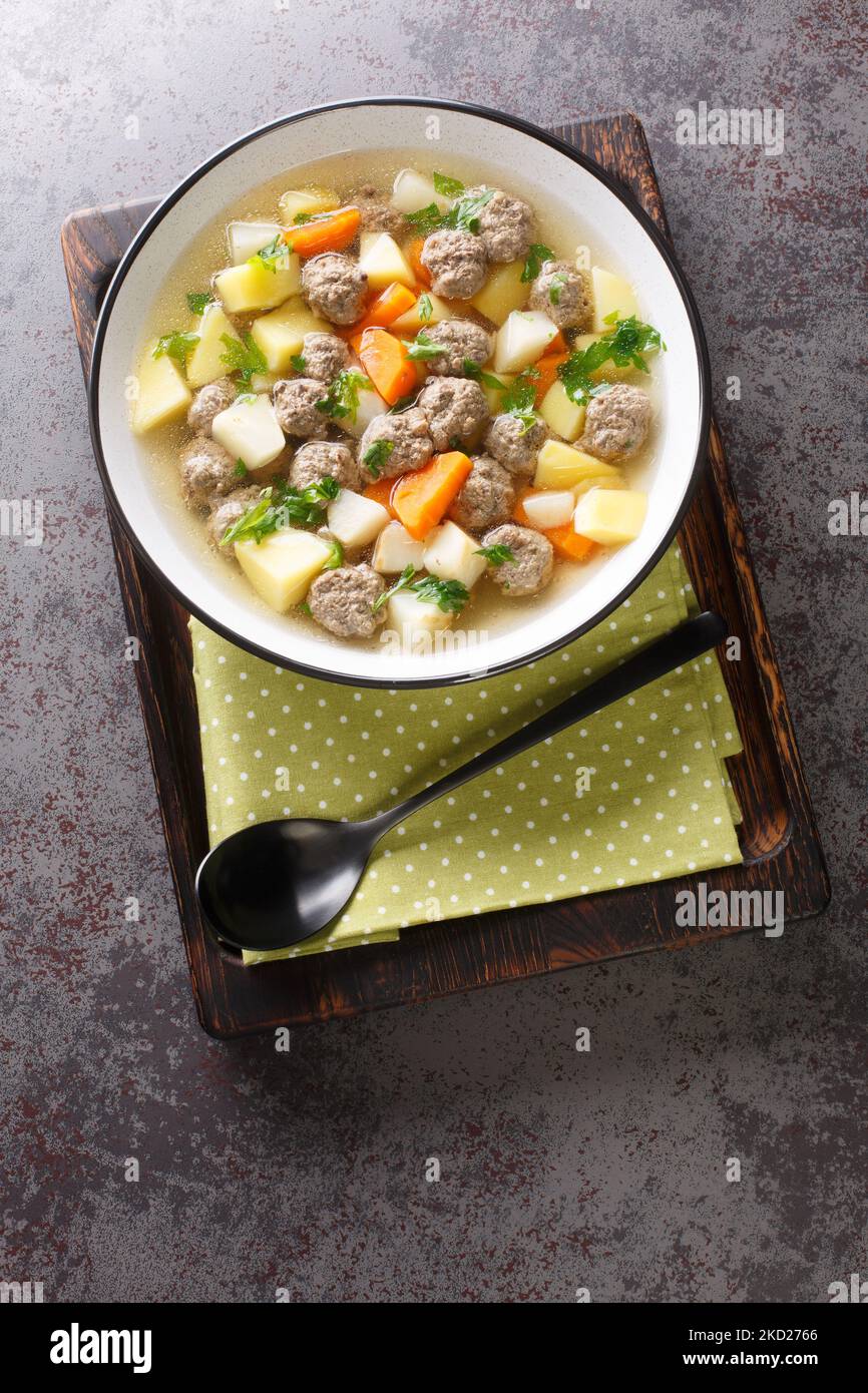 Sodd ist eine traditionelle norwegische Suppe aus gekochtem Hammelfleisch und Fleischbällchen und Kartoffeln, Karotten sind in einer klaren, duftenden Brühe in der Nähe enthalten Stockfoto