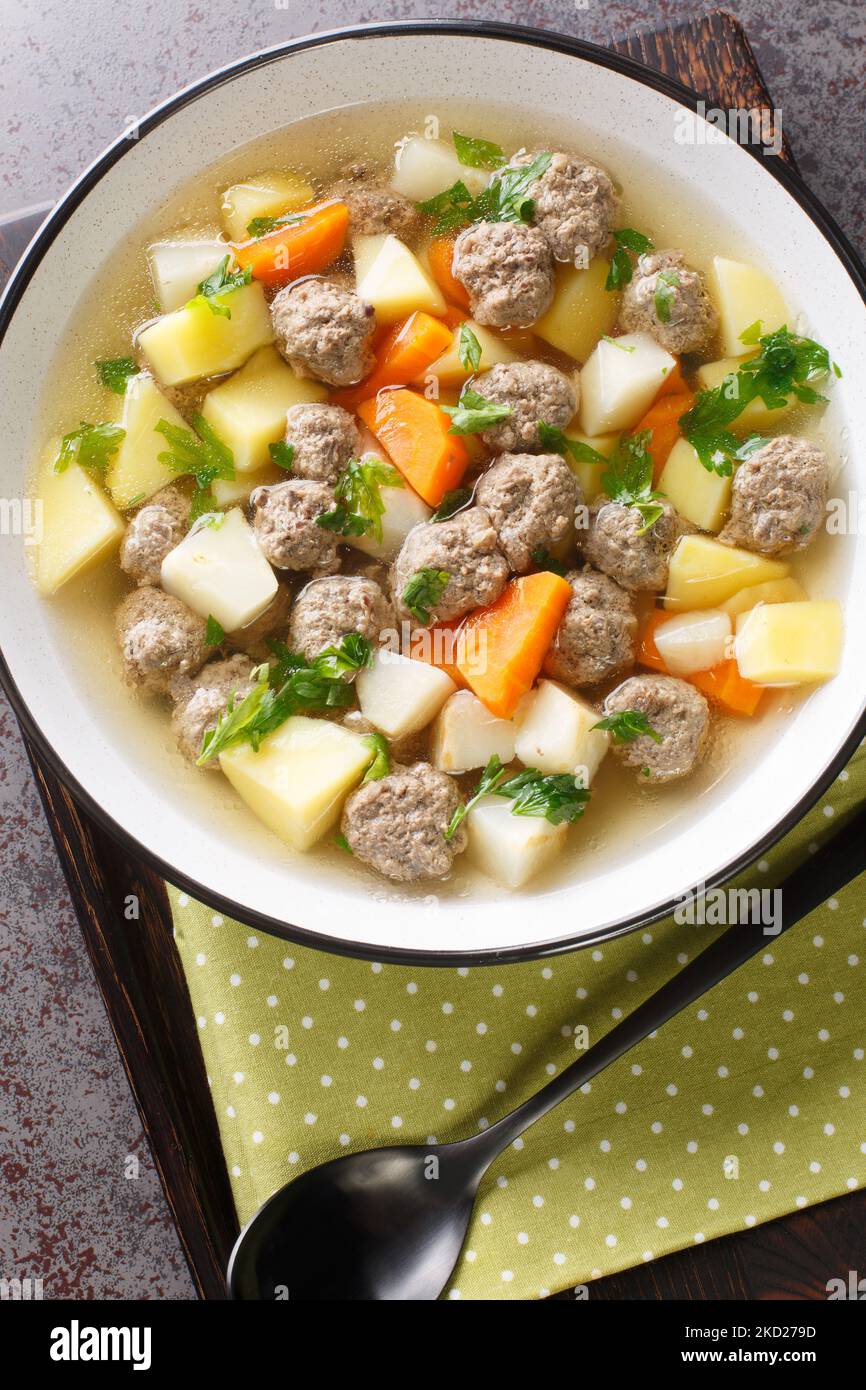 Sodd ist eine Fleisch- und Gemüsesuppe, bestehend aus Lamm, Fleischbällchen, Karotten und Kartoffeln in der Nähe auf dem Teller auf dem Tisch. Vertikale Draufsicht von oben Stockfoto