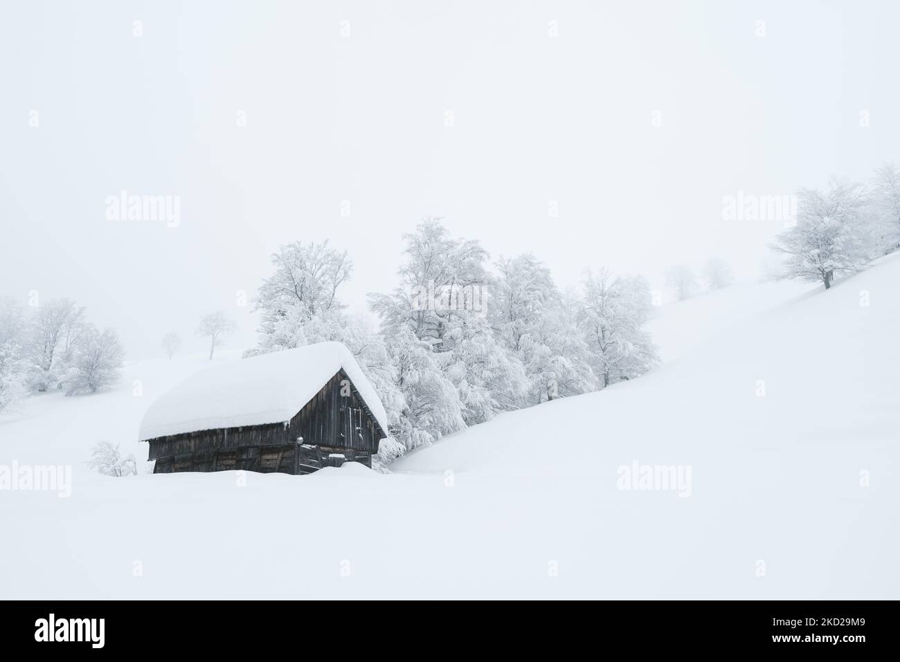 Winterlandschaft mit Holzhütte in verschneiten Bergen Stockfoto