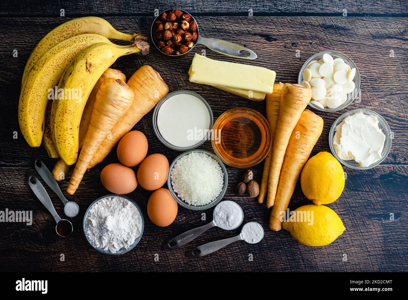 Geschmolzener Candle Cakes Zutaten Flatlay: Rohzutaten für Pastinak-Bananenkuchen mit weißer Schokoladenglasur Stockfoto