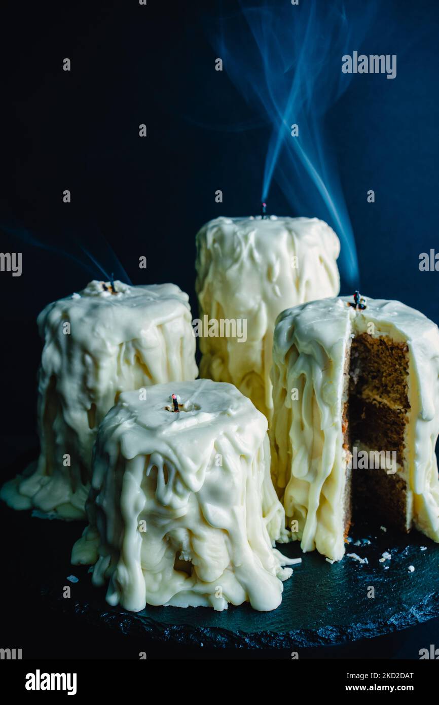 Geschmolzene Kerzenkuchen mit Rauchströmen: Kuchen, die auf einem dunkelschwarzen Hintergrund wie ausgesprengte Kerzen aussehen Stockfoto