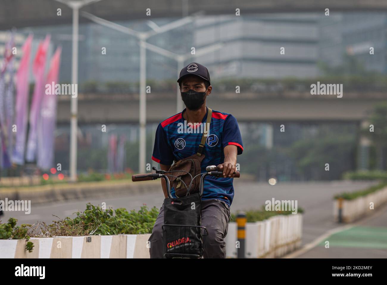 Der Mann trägt am 14. Februar 2022 Schutzmasken und fährt im Geschäftsviertel von Jakarta mit dem Fahrrad. Die Ministerin für Manpower, Ida Fauziyah, schreibt vor, dass die Zahlung von Altersleistungen oder JHT nur ausgezahlt werden kann, wenn die Teilnehmer der BPJS Ketenagakerjaan (Versicherung) 56 Jahre alt sind. Zu den JHT-Vorteilen für Teilnehmer, die das Rentenalter erreichen, gehören auch Teilnehmer, die ihre Arbeit einstellen. Teilnehmer, die ihre Arbeit einstellen, sind unter anderem Arbeitnehmer, die zurücktreten, von der Beendigung des Arbeitsverhältnisses betroffen sind und diejenigen, die Indonesien für immer verlassen. (Foto von Afriadi Hikmal/NurPhoto) Stockfoto