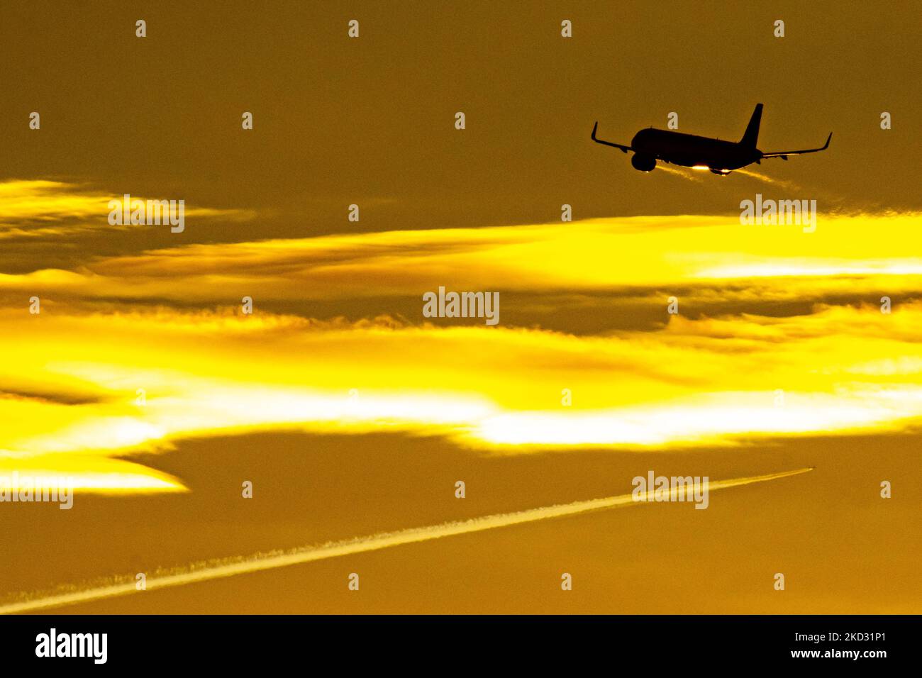 Flugzeug Silhouette, ein Symbol Illustration Foto während der magischen Stunde. Abenddämmerung und Sonnenuntergang goldene Stunde mit einem bunten bewölkten Himmel in Eindhoven. Bilder eines dunkel geformten Airbus A320-Flugzeugs, das in der farbenfrohen europäischen Skyscape abfliegt und fliegt. Die Luftfahrtindustrie und der Personenverkehr befinden sich in einer schwierigen Phase, da die Coronavirus-Pandemie Covid-19 negative Auswirkungen auf die Luft- und Reisebranche hat und aufgrund der neuen Omega-Variantenmutation eine Verschlechterung der Situation befürchtet wird. Eindhoven, Niederlande am 7. Februar 2022 (Foto: Nicolas Economou/NurPhoto) Stockfoto