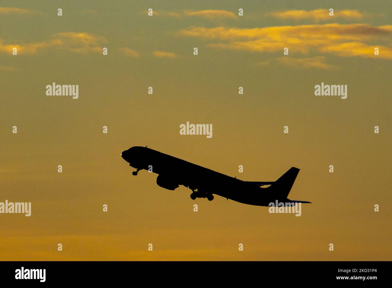 Flugzeug Silhouette, ein Symbol Illustration Foto während der magischen Stunde. Abenddämmerung und Sonnenuntergang goldene Stunde mit einem bunten bewölkten Himmel in Eindhoven. Bilder eines dunkel geformten Airbus A320-Flugzeugs, das in der farbenfrohen europäischen Skyscape abfliegt und fliegt. Die Luftfahrtindustrie und der Personenverkehr befinden sich in einer schwierigen Phase, da die Coronavirus-Pandemie Covid-19 negative Auswirkungen auf die Luft- und Reisebranche hat und aufgrund der neuen Omega-Variantenmutation eine Verschlechterung der Situation befürchtet wird. Eindhoven, Niederlande am 7. Februar 2022 (Foto: Nicolas Economou/NurPhoto) Stockfoto