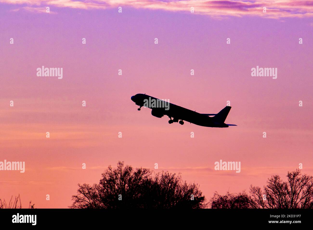 Flugzeug Silhouette, ein Symbol Illustration Foto während der magischen Stunde. Abenddämmerung und Sonnenuntergang goldene Stunde mit einem bunten bewölkten Himmel in Eindhoven. Bilder eines dunkel geformten Airbus A320-Flugzeugs, das in der farbenfrohen europäischen Skyscape abfliegt und fliegt. Die Luftfahrtindustrie und der Personenverkehr befinden sich in einer schwierigen Phase, da die Coronavirus-Pandemie Covid-19 negative Auswirkungen auf die Luft- und Reisebranche hat und aufgrund der neuen Omega-Variantenmutation eine Verschlechterung der Situation befürchtet wird. Eindhoven, Niederlande am 7. Februar 2022 (Foto: Nicolas Economou/NurPhoto) Stockfoto