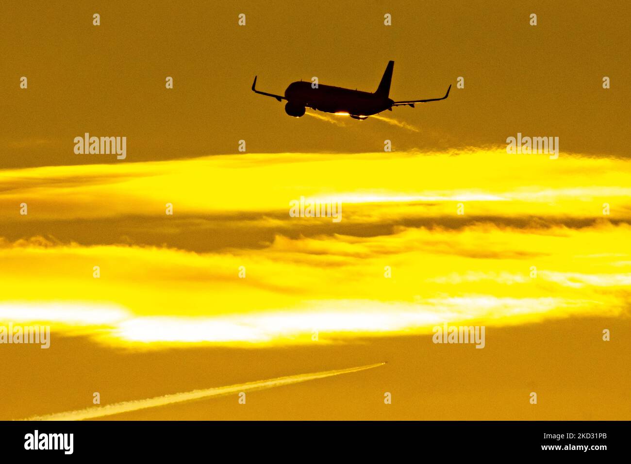 Flugzeug Silhouette, ein Symbol Illustration Foto während der magischen Stunde. Abenddämmerung und Sonnenuntergang goldene Stunde mit einem bunten bewölkten Himmel in Eindhoven. Bilder eines dunkel geformten Airbus A320-Flugzeugs, das in der farbenfrohen europäischen Skyscape abfliegt und fliegt. Die Luftfahrtindustrie und der Personenverkehr befinden sich in einer schwierigen Phase, da die Coronavirus-Pandemie Covid-19 negative Auswirkungen auf die Luft- und Reisebranche hat und aufgrund der neuen Omega-Variantenmutation eine Verschlechterung der Situation befürchtet wird. Eindhoven, Niederlande am 7. Februar 2022 (Foto: Nicolas Economou/NurPhoto) Stockfoto
