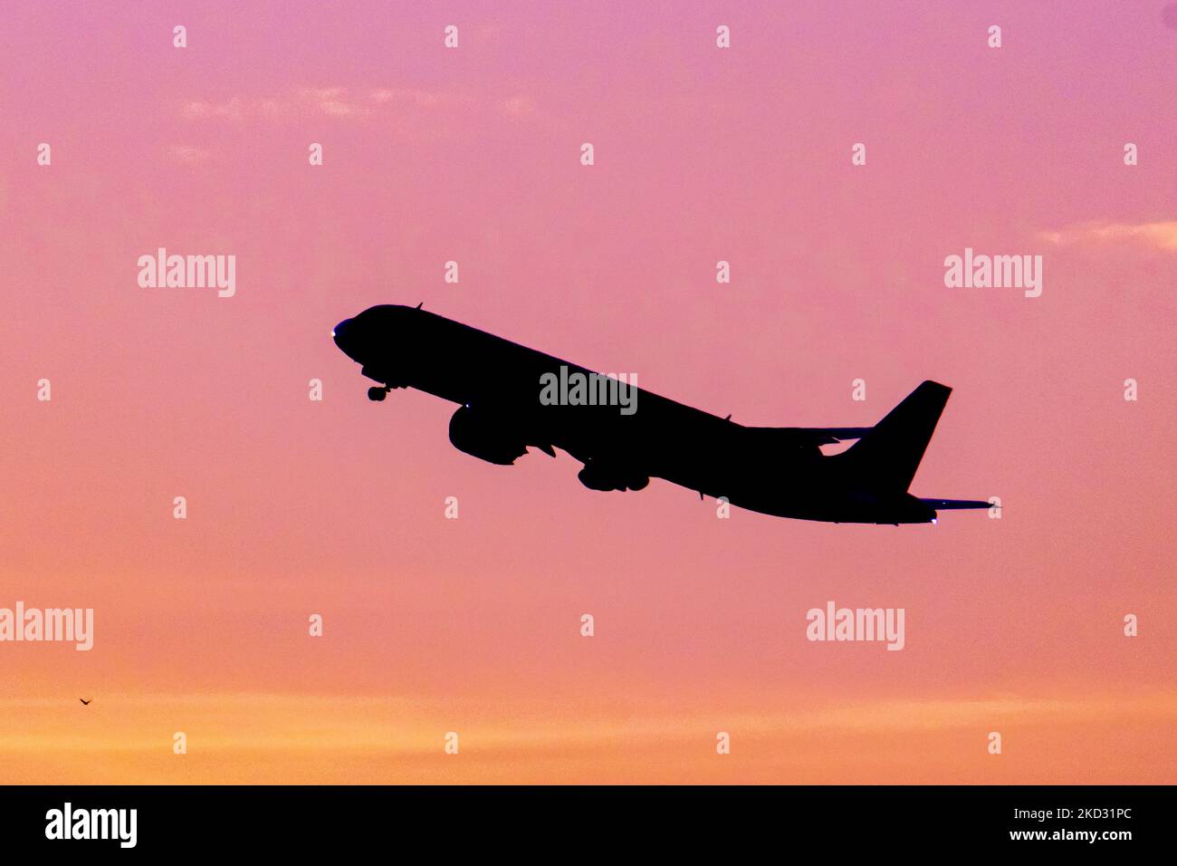 Flugzeug Silhouette, ein Symbol Illustration Foto während der magischen Stunde. Abenddämmerung und Sonnenuntergang goldene Stunde mit einem bunten bewölkten Himmel in Eindhoven. Bilder eines dunkel geformten Airbus A320-Flugzeugs, das in der farbenfrohen europäischen Skyscape abfliegt und fliegt. Die Luftfahrtindustrie und der Personenverkehr befinden sich in einer schwierigen Phase, da die Coronavirus-Pandemie Covid-19 negative Auswirkungen auf die Luft- und Reisebranche hat und aufgrund der neuen Omega-Variantenmutation eine Verschlechterung der Situation befürchtet wird. Eindhoven, Niederlande am 7. Februar 2022 (Foto: Nicolas Economou/NurPhoto) Stockfoto
