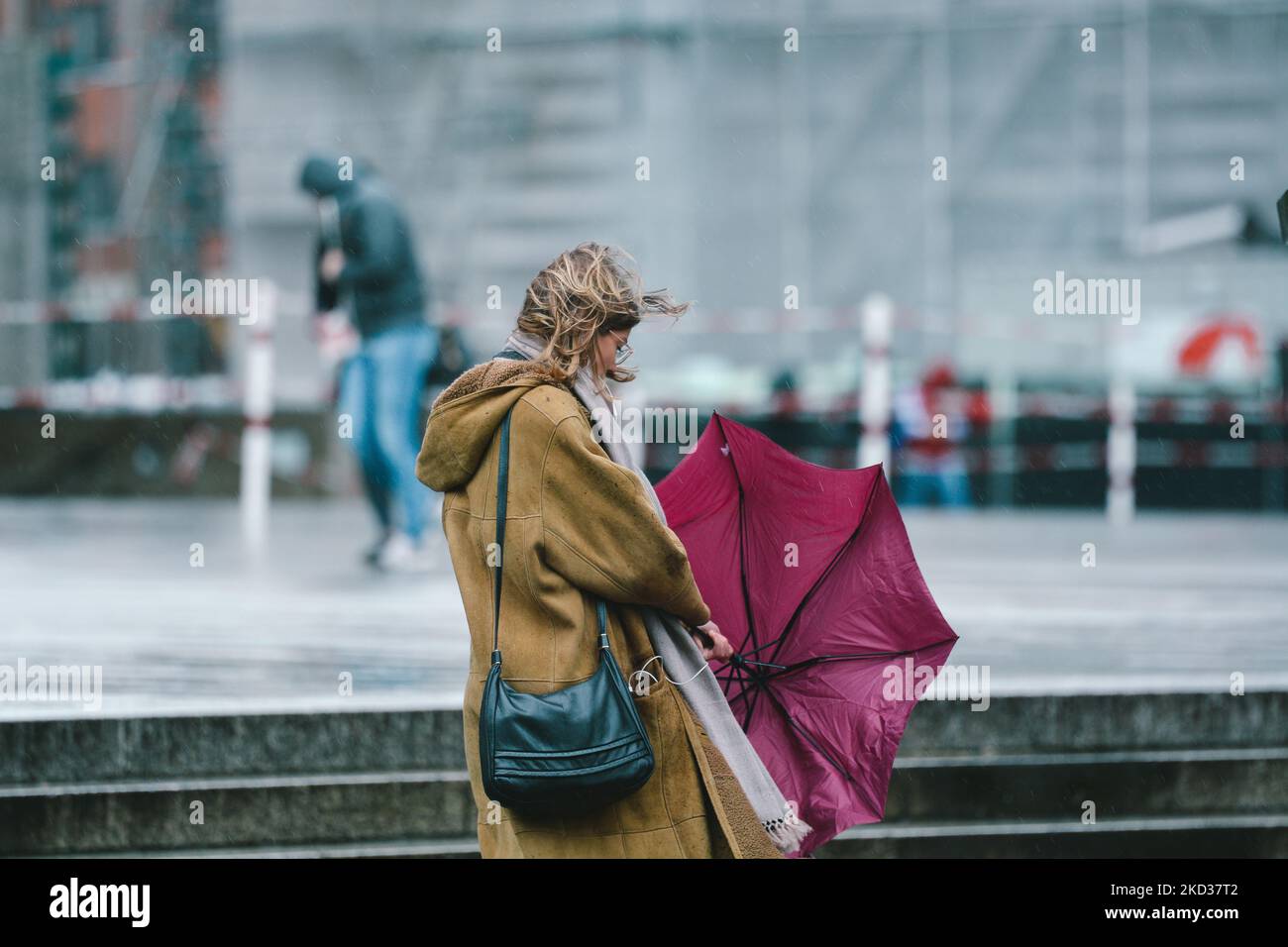 Eine Frau kämpft mit ihrem Regenschirm gegen den stromwind vor dem Kölner  Dom in Köln, Deutschland, am 21. Februar 2022 als Antonia den dritten Sturm  in Deutschland trifft (Foto: Ying Tang/NurPhoto Stockfotografie -
