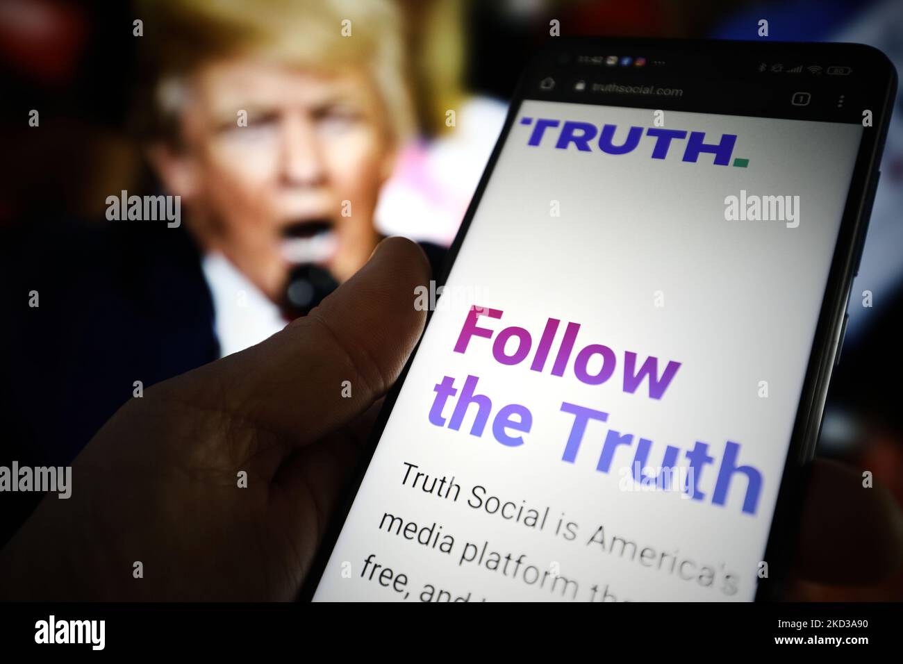 Die WEBSITE „THE TRUTH Social“ ist auf einem mobilen Gerät zu sehen. Im Hintergrund ist ein Bild des ehemaligen US-Präsidenten Donald Trump zu sehen, das am 23. Februar 2022 in Warschau, Polen, zu sehen ist. TRUTH Social ist eine neu entwickelte Social-Media-Plattform der Trump Media and Technology Group (TMTG) nach dem Vorbild von Twitter. Die Initiative wurde ergriffen, nachdem Trump selbst 2021 von Facebook und Twitter verbannt worden war. (Foto von STR/NurPhoto) Stockfoto